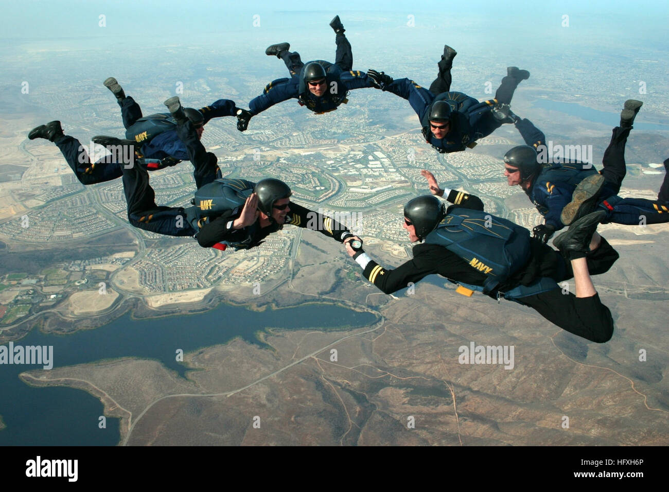 Aviation Structural Mechanic 1st Class viene arruolato da un tenente, mentre altri membri della squadra di paracadutisti Leap Frogs Navy osservano in alto sopra San Diego. Le Leap Frogs sono costituite da SEAL della Marina degli Stati Uniti e personale di Special Warfare Combatant-Craft Crewman. Foto Stock
