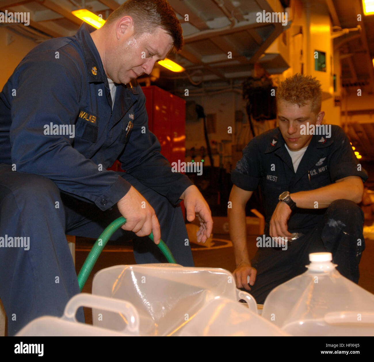 080912-N-7544A-024 MAR DEI CARAIBI (sett. 12, 2008) Capo da bombardieri Mate William Walker e aviazione Ordnanceman 3rd Class Chris West, sia imbarcato a bordo dell'assalto anfibio nave USS Kearsarge (LHD3) riempire due-e-un-mezzo litro di acqua contenitori per la consegna alla comunità di Haiti colpite dagli uragani. Kearsarge è stato deviato dalla prevista continuando promessa 2008 assistenza umanitaria la distribuzione nella parte occidentale dei Caraibi per condurre Hurricane Relief Operations in Haiti. (U.S. Foto di Marina di Massa lo specialista di comunicazione di terza classe Angebrand Maddelin/RILASCIATO) Navy US 080912-N-7544A-02 Foto Stock