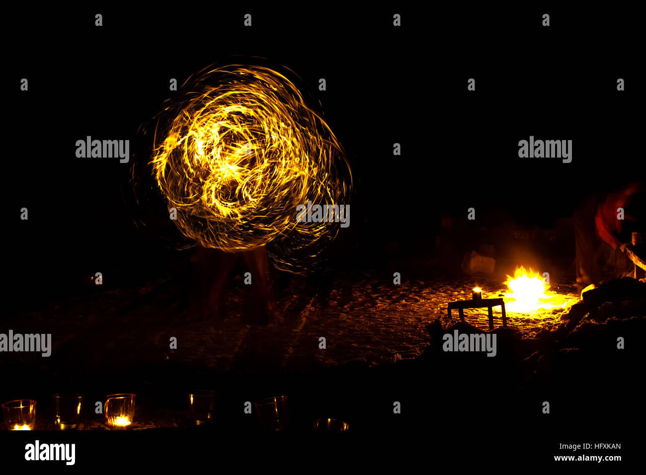 Forma di cuore di candele accese sul terreno su uno sfondo di fire show. Foto Stock