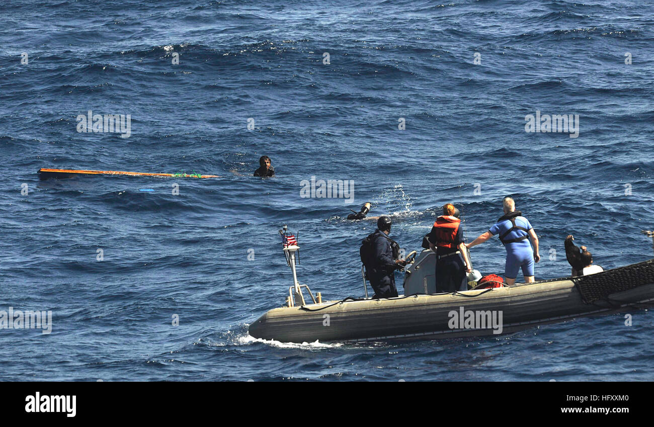 091117-N-9500T-272 Golfo di Aden (nov. 17, 2009), la ricerca e il salvataggio del nuotatore turbina a gas meccanica di sistemi di seconda classe Alfredo Rodriguez, assegnati alle visite-missili cruiser USS scelto (CG 65), nuota verso l'ultimo dei tre uomini aggrappato a un pezzo di legno nel Golfo di Aden. Gli uomini sono stati avvistati da un civile nave cargo, che radioed per assistenza. Chosin è il prodotto di punta della Combined Joint Task Force 151, una task force multinazionale istituito per condurre una lotta alla pirateria operazioni nel quadro di una missione-basato il mandato di impegnarsi attivamente per dissuadere, interrompere e sopprimi la pirateria al largo della Somalia. (U.S. Navy p Foto Stock