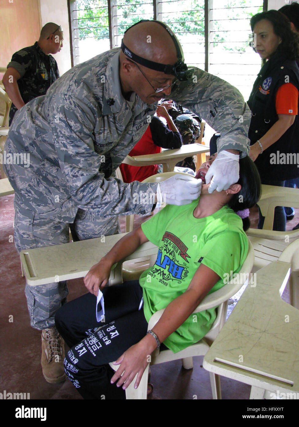 091128-N-1008D-082 Jolo, Filippine (nov. 28, 2009) DEGLI STATI UNITI Air Force Lt. Col. Arnold Stocker, un infermiere anestesista assegnato alla Joint Special Operations Task Force-Philippines, estrae un dente da una giovane ragazza durante una visita medica di azione civica progetto (MEDCAP). Guidati da forze armate delle Filippine, JSOTF-P I membri assistiti con il trattamento di più di 200 pazienti per cure dentarie, medical check-up e distribuiti farmaci e prodotti da toeletta. (U.S. Navy foto di Lt.j.g. Theresa Donnelly/RILASCIATO) Navy US 091128-N-1008D-082 t. Col. Arnold Stocker estrae un dente da una giovane ragazza durante una Foto Stock