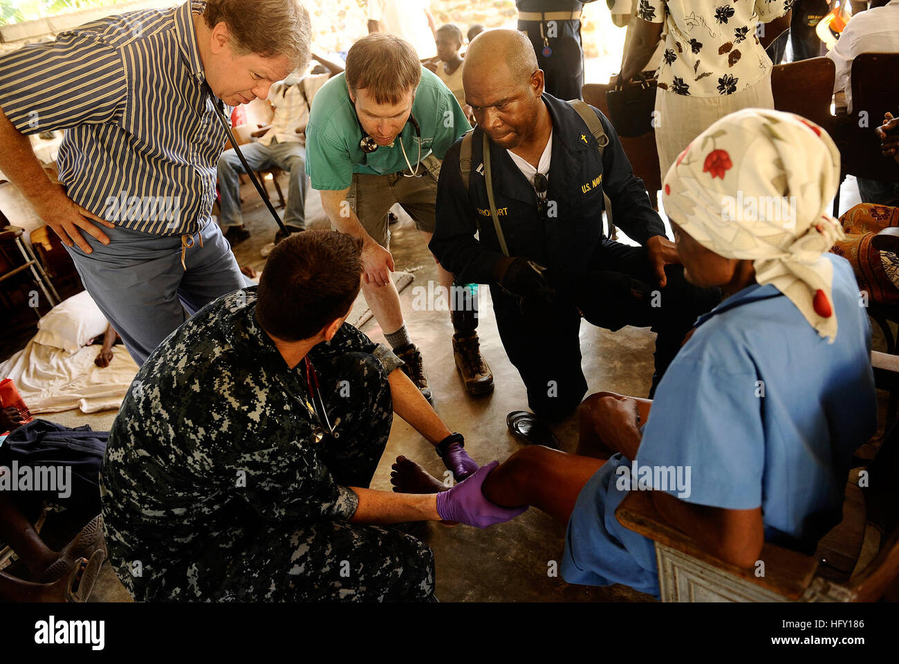 100129-N-5345W-189 Grand Goave, Haiti (GEN. 29, 2010) Lt. La Cmdr. Jeffrey Lester, in basso a sinistra, un medico imbarcato a bordo del multi-purpose Amphibious Assault nave USS Bataan (LHD 5), descrive una donna haitiana di lesioni alla visita ai membri di Medici Senza Frontiere mentre esaminare pazienti a Lifeline ministeri cristiani missione clinica medica in Grand Goave, Haiti. Bataan è il supporto di funzionamento risposta unificata a seguito di un terremoto di magnitudine 7.0 che hanno provocato gravi danni in Haiti a gennaio 12. (U.S. Foto di Marina di Massa lo specialista di comunicazione 2a classe Kristopher Wilson/RILASCIATO) Noi Na Foto Stock