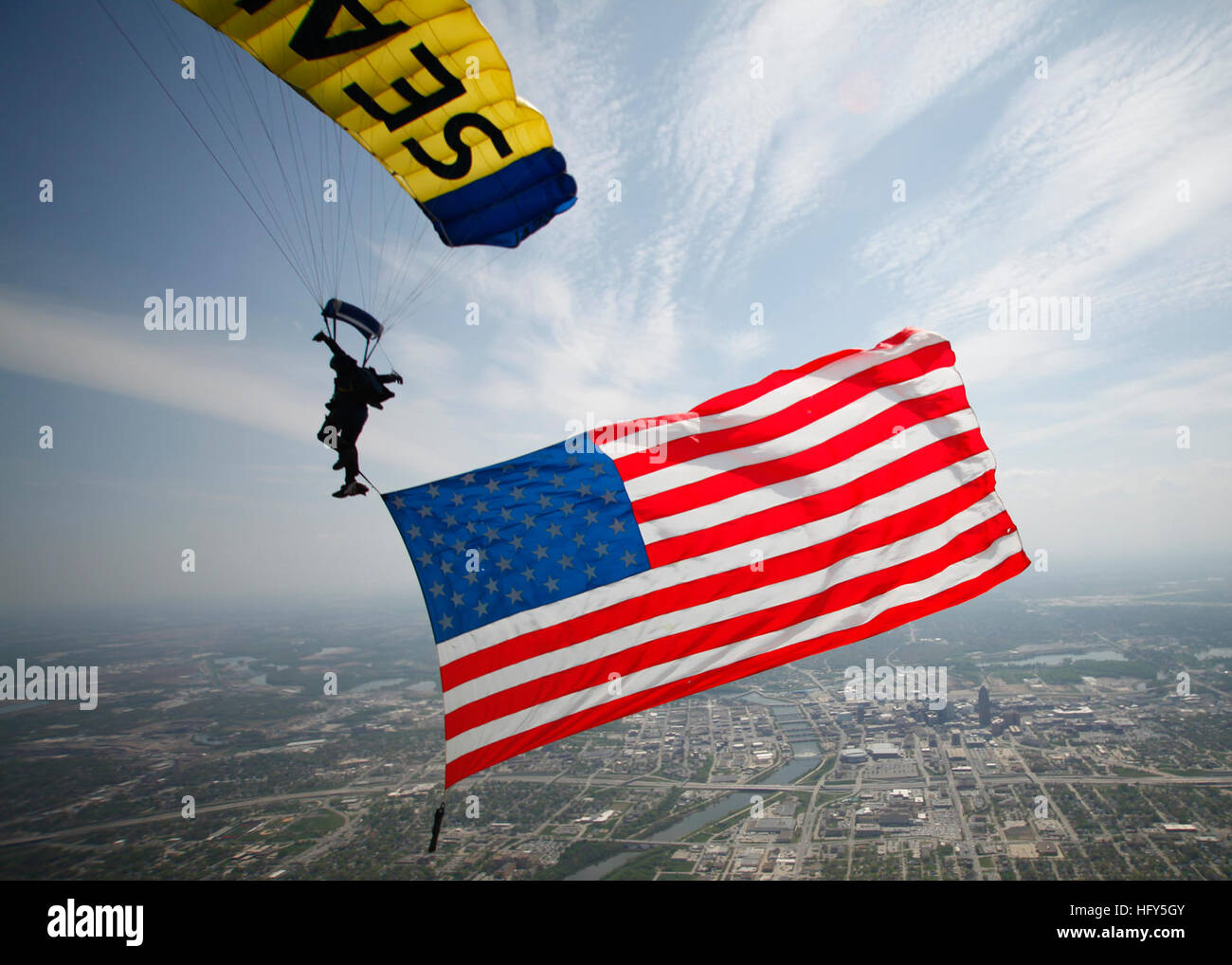 100420-N-0000L-023 Des Moines, Iowa (20 aprile 2010) equipaggi Equipmentman sopravvivenza 1a classe Thomas Kinn, assegnato per gli Stati Uniti Navy parachute team di dimostrazione, il salto delle rane, mosche una bandiera americana al di sopra di Des Moines, Iowa, prima di atterrare a nord di alta scuola. Il team eseguita presso la scuola a sostegno del Navy settimana. Des Moines Navy settimana è uno dei 20 Navy settimane previsto attraverso l'America nel 2010. Navy settimane sono progettati per mostrare gli americani gli investimenti che hanno fatto nel loro marina e aumentare la consapevolezza in città che non hanno una significativa presenza della Marina. (U.S. Navy foto di capo di guerra speciale Foto Stock