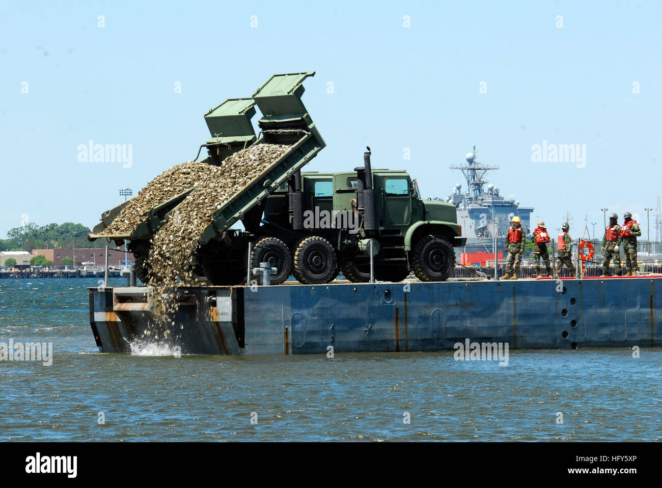 100428-N-3154P-149 Virginia Beach, Va. (28 aprile 2010) velisti assegnati alla costruzione di anfibio battaglione (ACB) 2, dump valve oyster nel fango appartamenti di Little Creek Cove di istituire due nuovi artificiali barriere coralline di Oyster. Le ostriche sono la naturale Ostrica orientale, Crassostrea virginica, che è in grado di filtrare 50 galloni di acqua singolarmente ogni giorno. (U.S. Foto di Marina di Massa Specialista comunicazione marinaio Scott Pittman/RILASCIATO) Navy US 100428-N-3154P-149 velisti assegnati alla costruzione di anfibio battaglione (ACB) 2, utilizzare macchinari pesanti a carico di gusci di ostrica per due nuove o artificiale Foto Stock