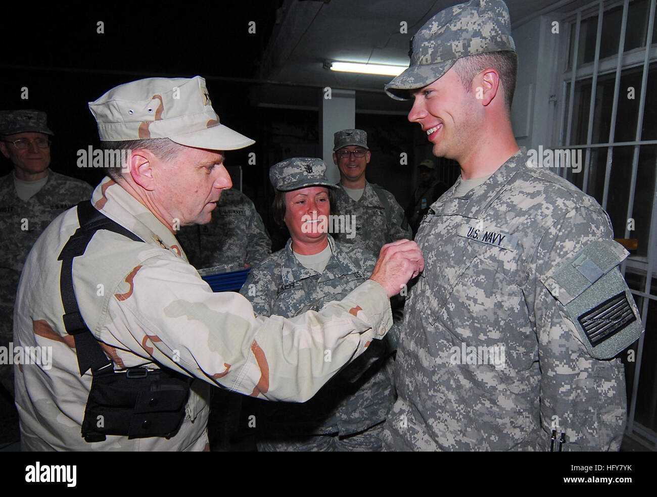 Kabul, Afghanistan - Vice Adm. Bill Gortney, sinistra, Commander, U.S. Navy le forze di Comando Centrale/5a flotta, chiodini un "Crow" su Petty Officer 1. Classe Christopher parchi come Chief Petty Officer Sliker Delisa, il suo sponsor, orologi durante una cerimonia frocking su Camp Eggers. Durante la sua visita a Camp Eggers, il quartier generale della NATO Training Mission - Afghanistan, Gortney si è incontrato con il comando personale, presiedette la cerimonia frocking per sei marinai e ha parlato apertamente di marinai circa l importanza della loro missione in Afghanistan.(US Navy Foto di Capo della comunicazione di massa specialista F. Julian Carroll)Rilasciare Foto Stock