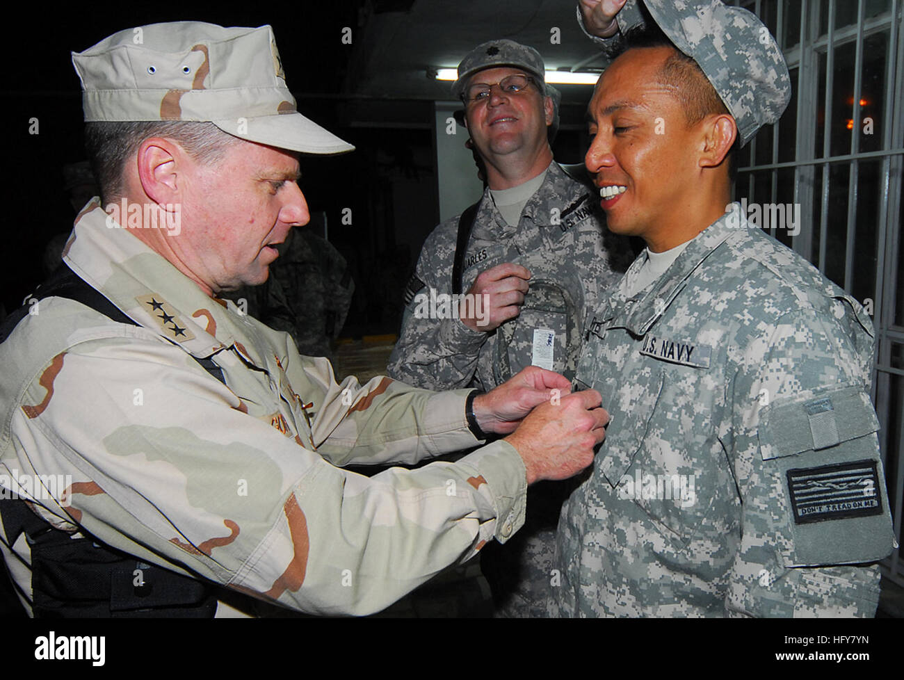 Kabul, Afghanistan - Vice Adm. Bill Gortney, sinistra, Commander, U.S. Navy le forze di Comando Centrale/5a flotta, chiodini un "Crow" sulla nuova frocked Petty Officer 1. Classe Sydney Reyes come quella della Cmdr. Christopher Quarles, il suo sponsor, sostituisce il suo coperchio durante una cerimonia frocking su Camp Eggers. Durante la sua visita a Camp Eggers, il quartier generale della NATO Training Mission - Afghanistan, Gortney si è incontrato con il comando personale, presiedette la cerimonia frocking per sei marinai e ha parlato apertamente di marinai circa l importanza della loro missione in Afghanistan.(US Navy Foto di Capo della comunicazione di massa specialista F. Julian auto Foto Stock