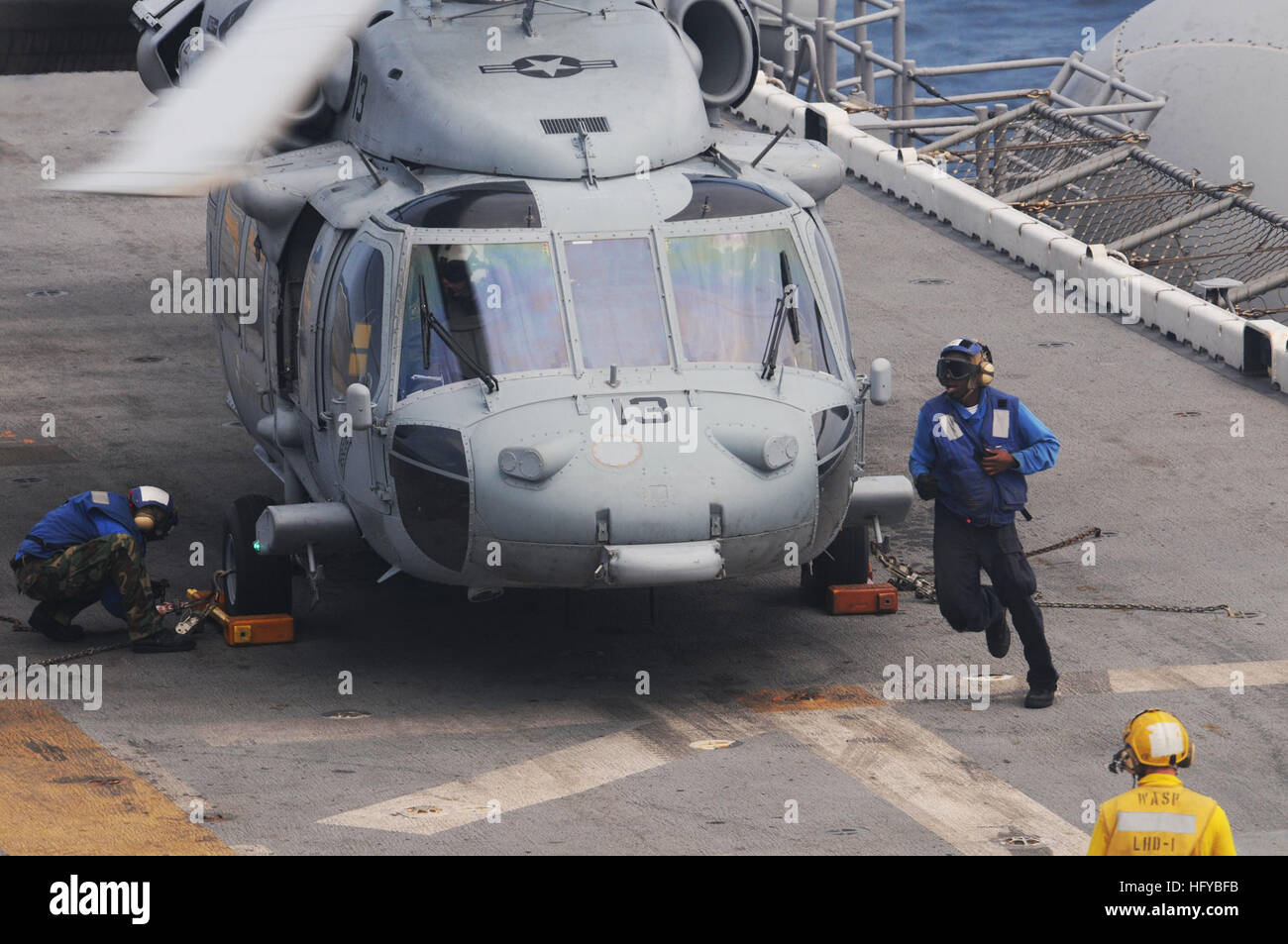 Petty Officer di terza classe Kristy Downing, sinistra e marinaio Eddie Berryhill guarnitura e catena un MH-60S Sea Hawk di ricerca e salvataggio in elicottero assegnato al mare Cavalieri del Mare in elicottero Combat Squadron 22 a bordo dell'assalto anfibio nave USS Wasp. Vespa è in corso il test di conduzione delle operazioni di volo ed è stato scelto come piattaforma per valutare i limiti e le funzionalità dei più recenti e aggiornati i modelli di aeromobile come ad esempio la MH-60S, AH-1Z Cobra e la UH-1Y Venom. USS Wasp operazioni di volo DVIDS307975 Foto Stock