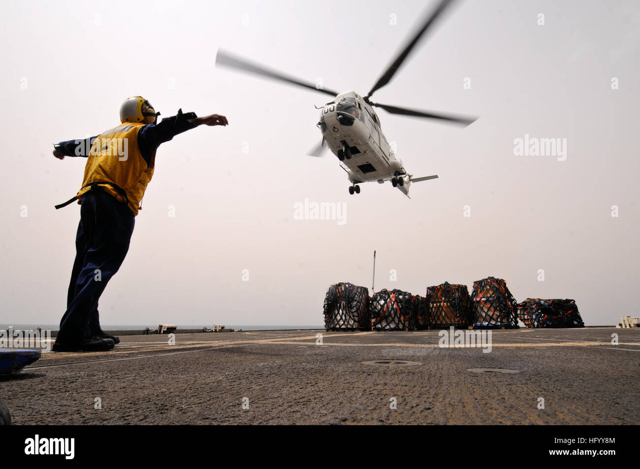 110721-N-YM590-082 Golfo di Aden (21 luglio 2011) di Boatswain Mate 3° di classe Jean Guerra i segnali di un elicottero Puma per il rilascio è il gancio di carico sul ponte di volo dell'guidato-missili cruiser USS Anzio (CG 68) durante un rifornimento verticale. Anzio è assegnato alla combinazione di Task Force 151, un multi-nazionale, basato su missioni task force istituita dalla combinazione di forze marittime nel gennaio 2009 per condurre una lotta alla pirateria operazioni nel Mare Rosso, il Golfo di Aden, bacino somalo e Mare Arabico. (U.S. Foto di Marina di Massa lo specialista di comunicazione 2a classe di Brian M. Brooks/RILASCIATO) Navy US 110721-N-YM590-082 Barche Foto Stock