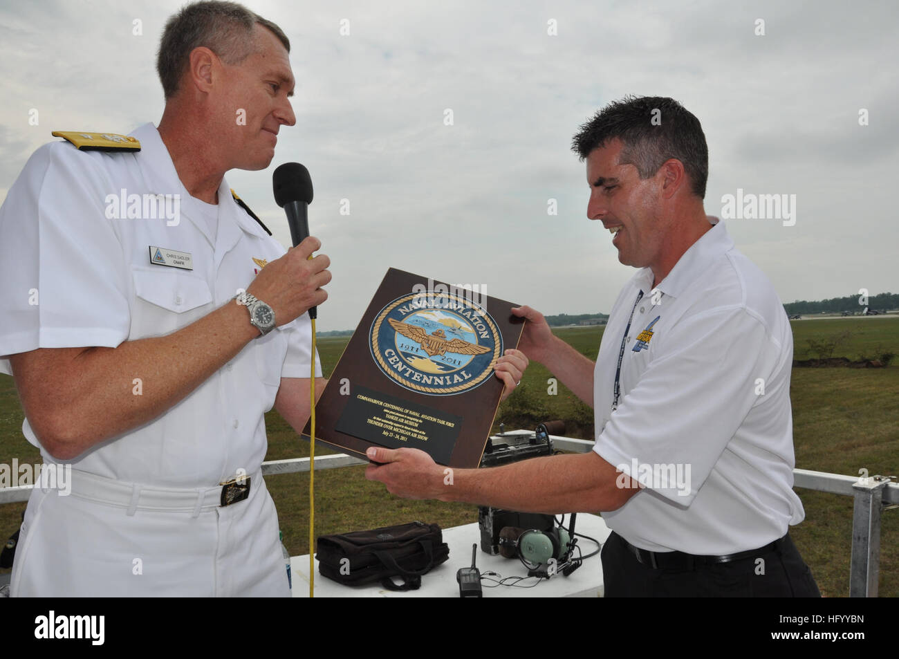 110723-N-SQ656-038 BELLEVILLE, Mich. (Luglio 23, 2011) posteriori Adm. Giovanni "Chris" Sadler, comandante della Naval Air Forces Riserva e vice comandante della Naval Air forze, presenta Kevin Walsh, direttore del tuono su Michigan Air Show air show e direttore di The Yankee Air Museum, con un Centennial of Naval Aviation placca. L'air show celebra il Centennial of Naval Aviation come parte di Detroit Navy Week 2011. Navy settimane sono destinate a mostrare gli investimenti americani hanno fatto nella loro marina e aumentare la consapevolezza in città che non hanno una significativa presenza della Marina. (U.S. Navy pho Foto Stock