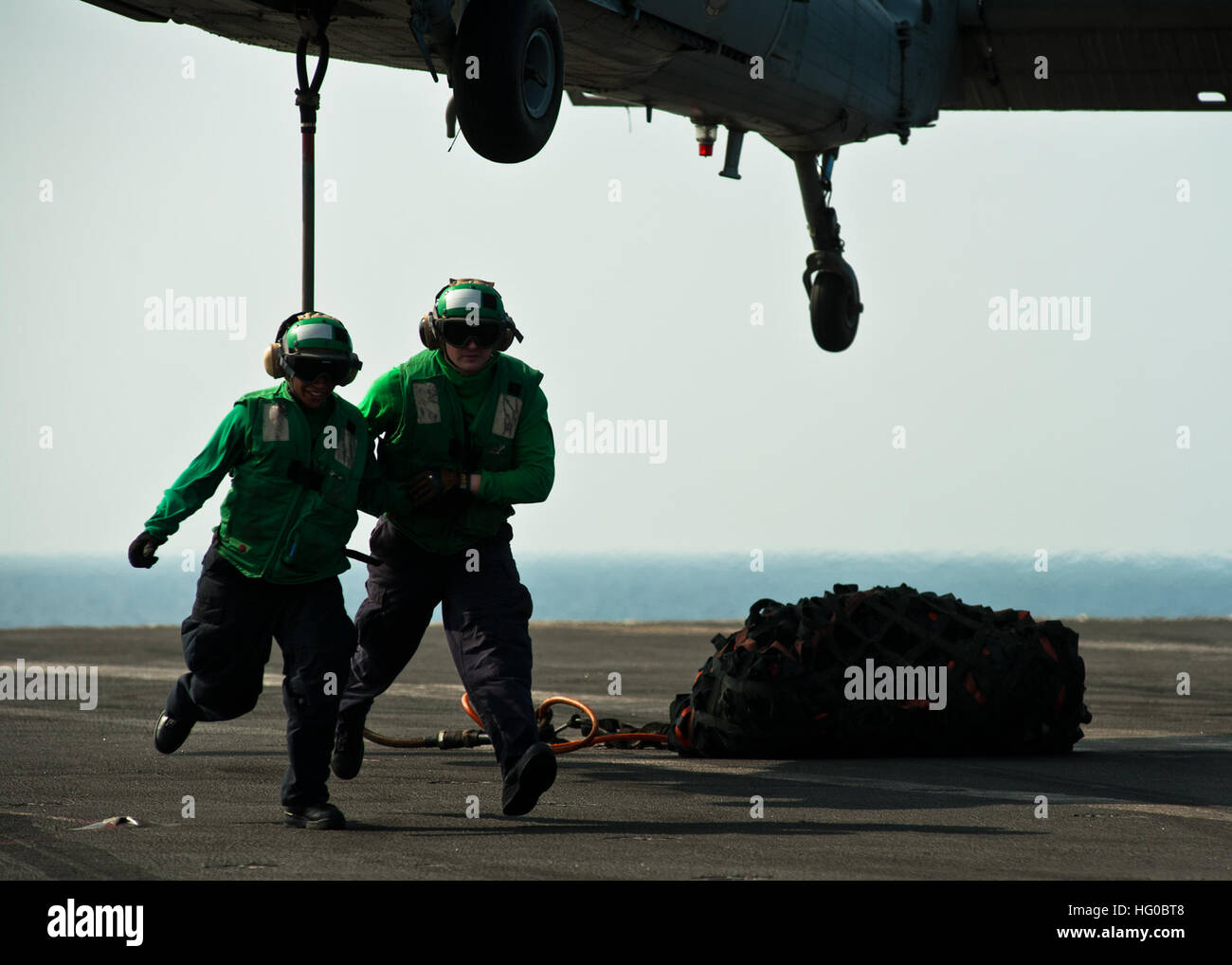 111229-N-BT887-517 Mare Arabico (dec. n. 29, 2011) specialista della logistica marinai Tyler Thiebault e Tomiya Norris sgombrare la zona dopo il fissaggio di un gancio per un MH-60S Sea Hawk elicottero dall'Eightballers di elicottero di mare squadrone di combattimento (HSC) 8 a bordo della Nimitz-class portaerei USS John C. Stennis (CVN 74). John C. Stennis è distribuito negli Stati Uniti Quinta Flotta area di responsabilità condurre le operazioni di sicurezza marittima e le missioni di sostegno come parte dell'Operazione Enduring Freedom. (U.S. Foto di Marina di Massa lo specialista di comunicazione di terza classe Benjamin Crossley/RILASCIATO) Navy US 111229-N-BT887 Foto Stock