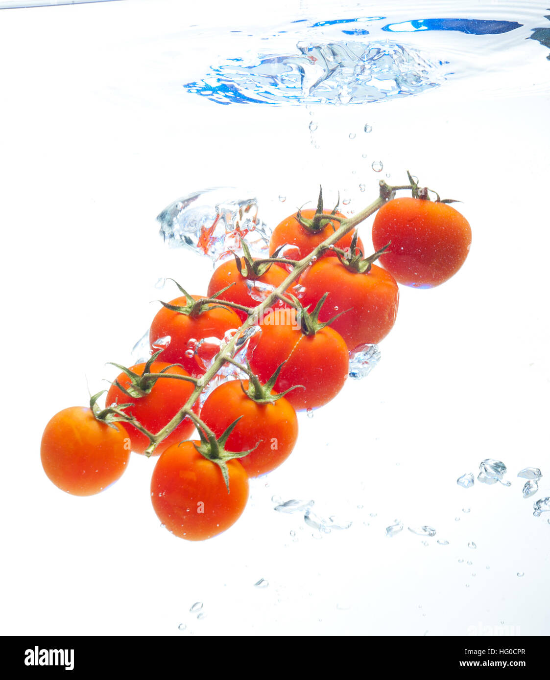 Il pomodoro galleggiante in acqua su sfondo bianco Foto Stock