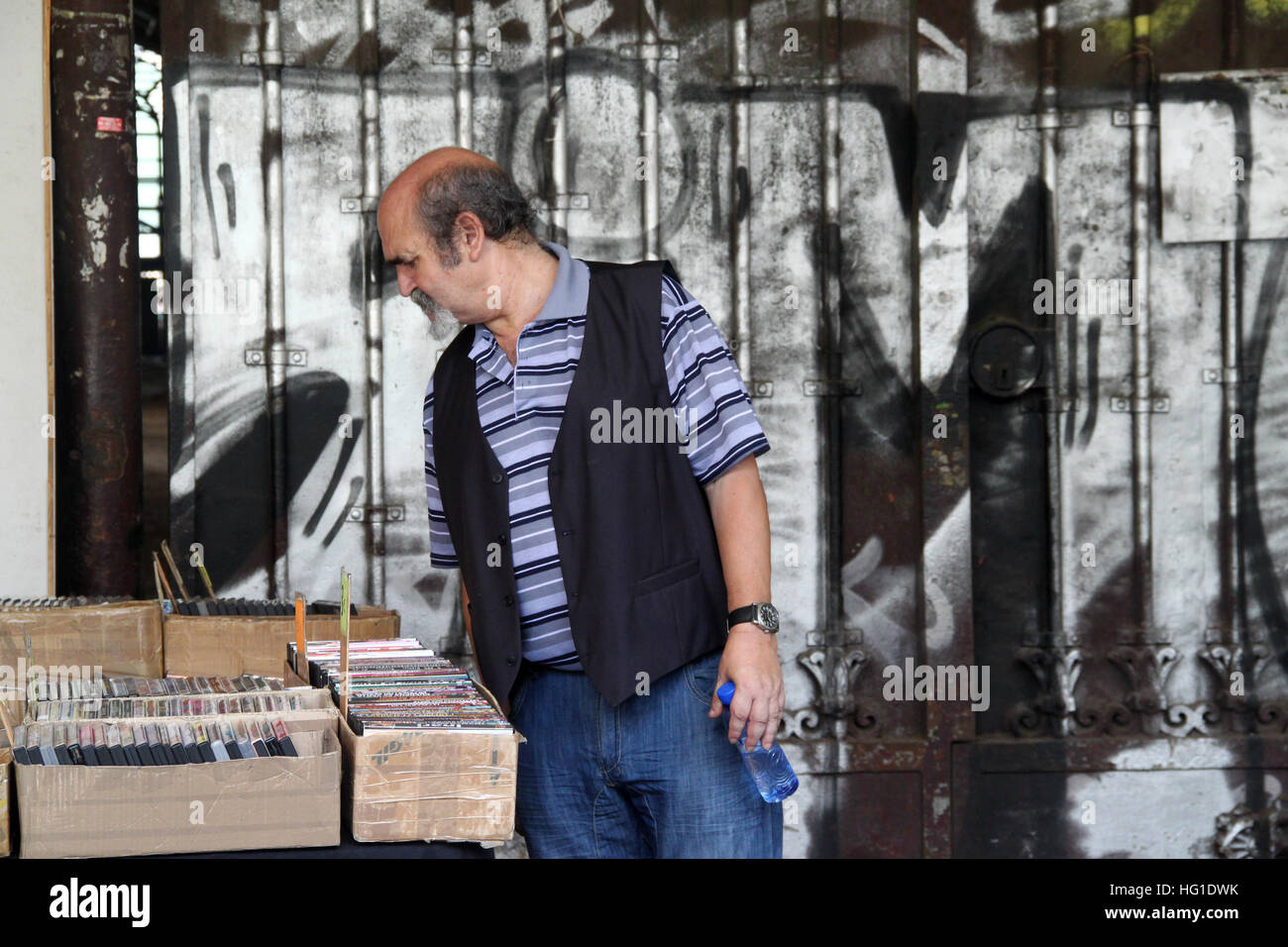 L'uomo la navigazione di seconda mano libri a Sant Antoni mercato di domenica a Barcellona Foto Stock