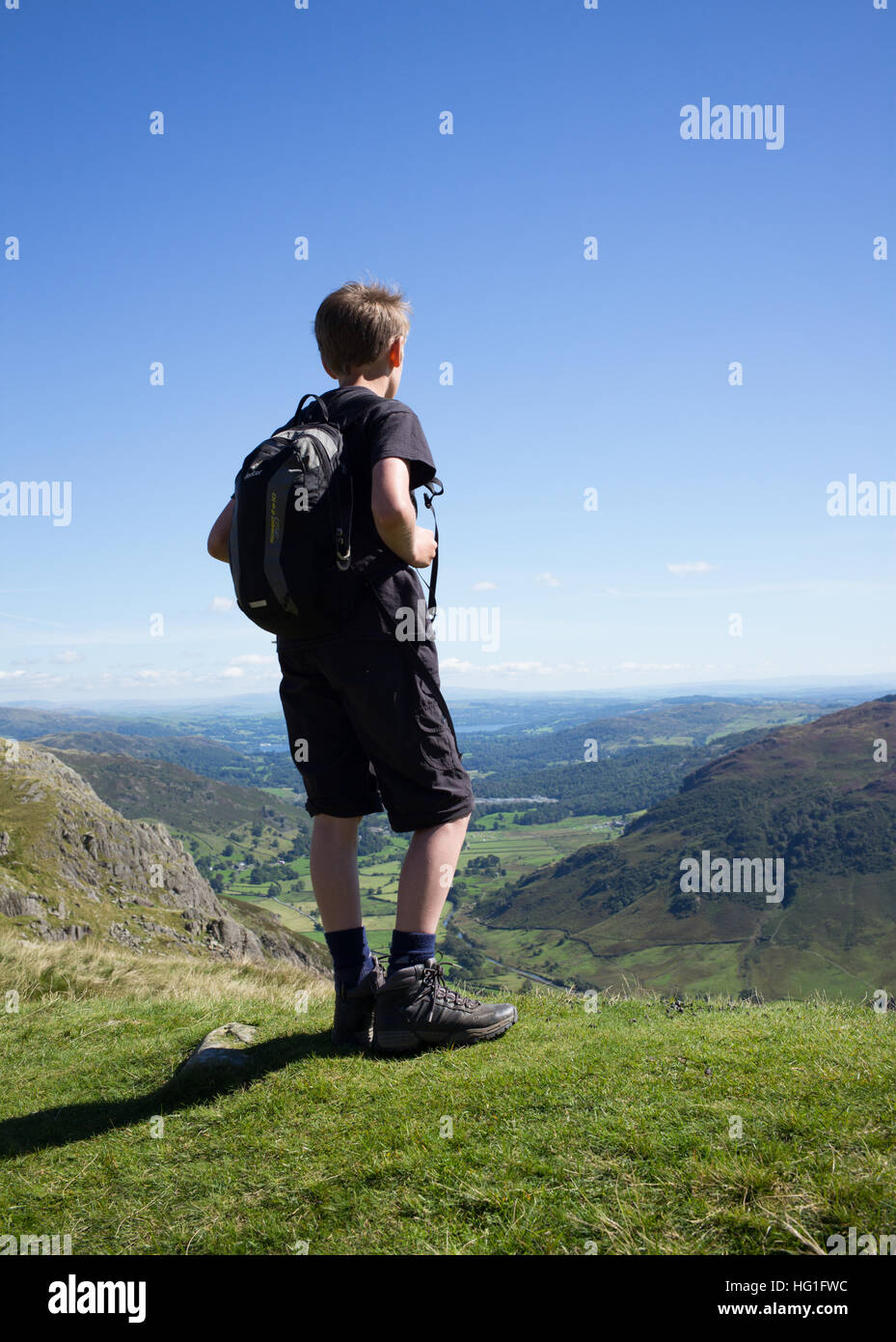 Un giovane maschio escursionista nel distretto del lago cercando la distanza da Stickle Tarn. Foto Stock