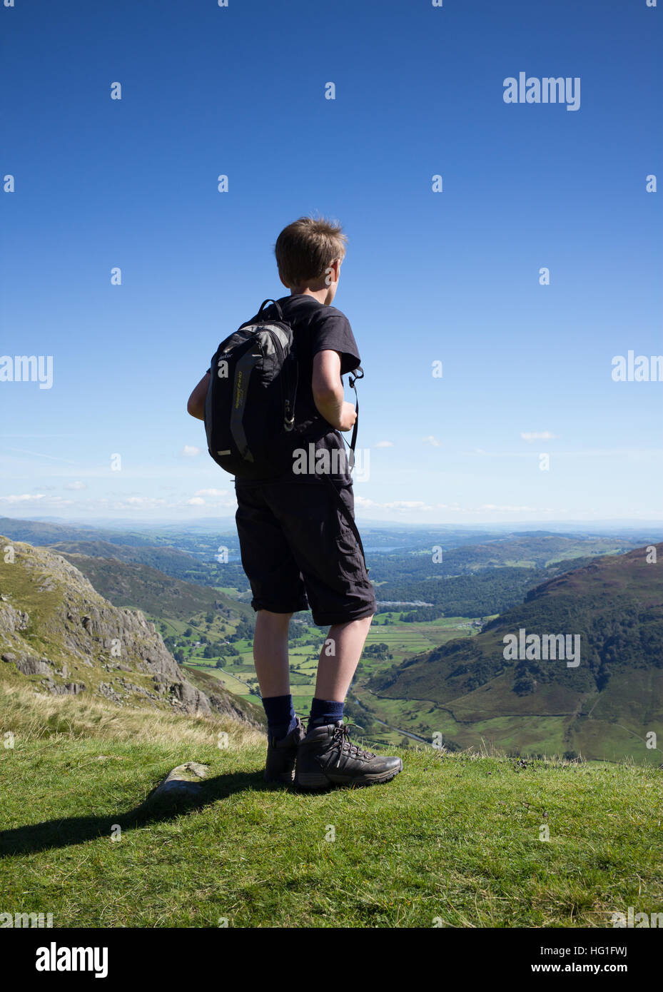 Un giovane maschio escursionista nel distretto del lago cercando la distanza da Stickle Tarn. Foto Stock