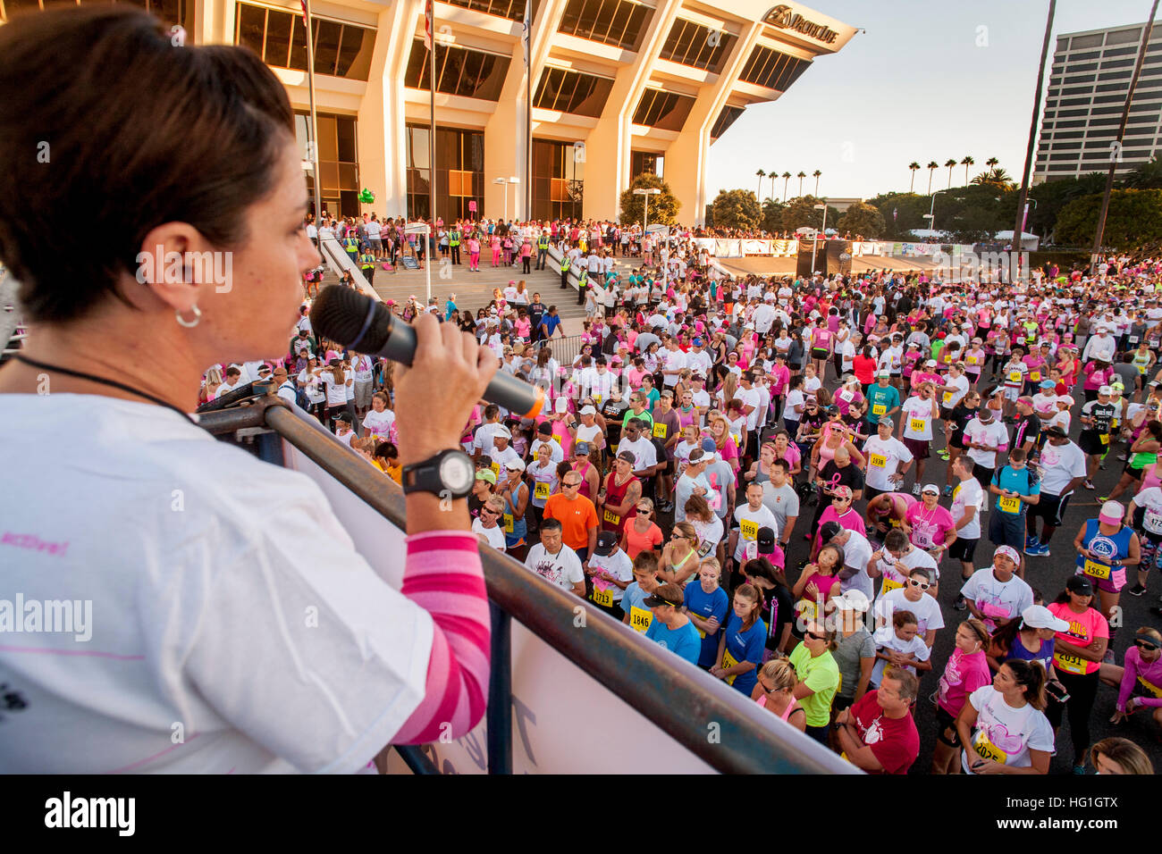 Un annunciatore risolve in attesa i partecipanti da una donna in una carità fund raising gara podistica in Newport Beach, CA. Foto Stock