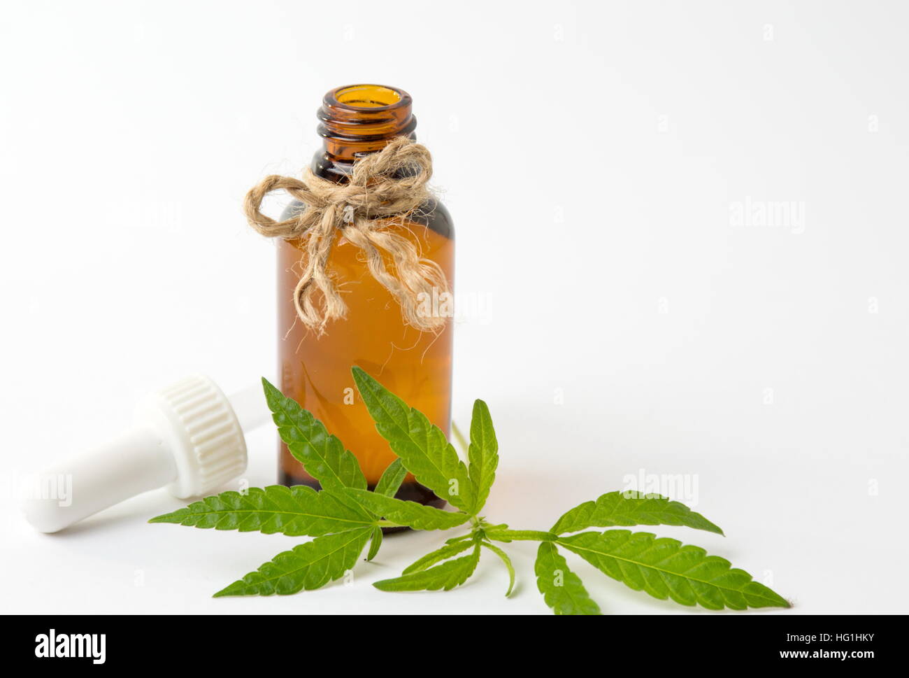 Foglie di cannabis e olio su sfondo bianco Foto Stock