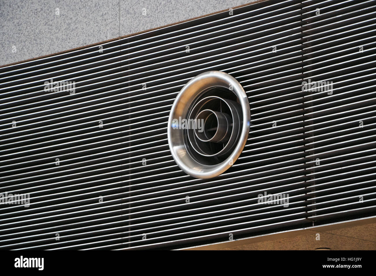Primo piano della forma rotonda sistema di ventilazione foro su una parete in un edificio di grandi dimensioni Foto Stock