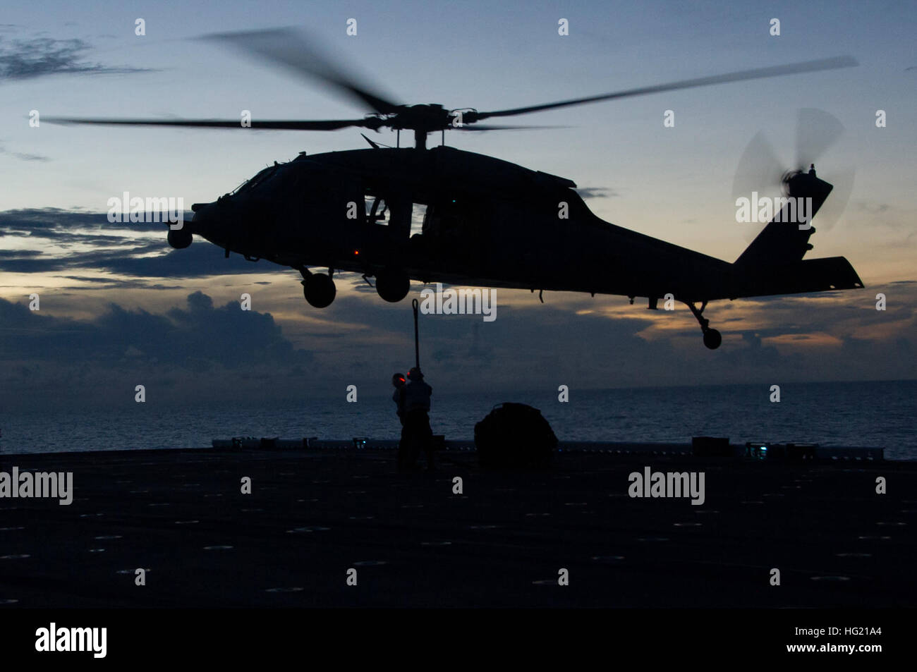 La USS America (LHA-6) effettua operazioni di rifornimento verticale con elicotteri MH-60S Seahawk in quanto i marines del Combat Cargo Department attaccano il carico sul ponte di volo durante il primo transito della nave nella zona della terza flotta degli Stati Uniti. Foto Stock