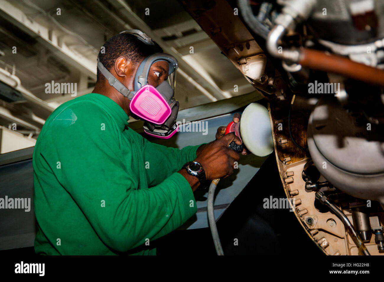 Aviation Structural Mechanic 2nd Class sabbia un F/A-18F Super Hornet dal VFA-22 nella zona hangar della USS Carl Vinson (CVN 70). Carl Vinson è schierato nella 5th Fleet area of Operations degli Stati Uniti a supporto dell'operazione Inherent Resolve, operazioni di sciopero, sicurezza marittima e cooperazione di sicurezza teatrale. Foto Stock