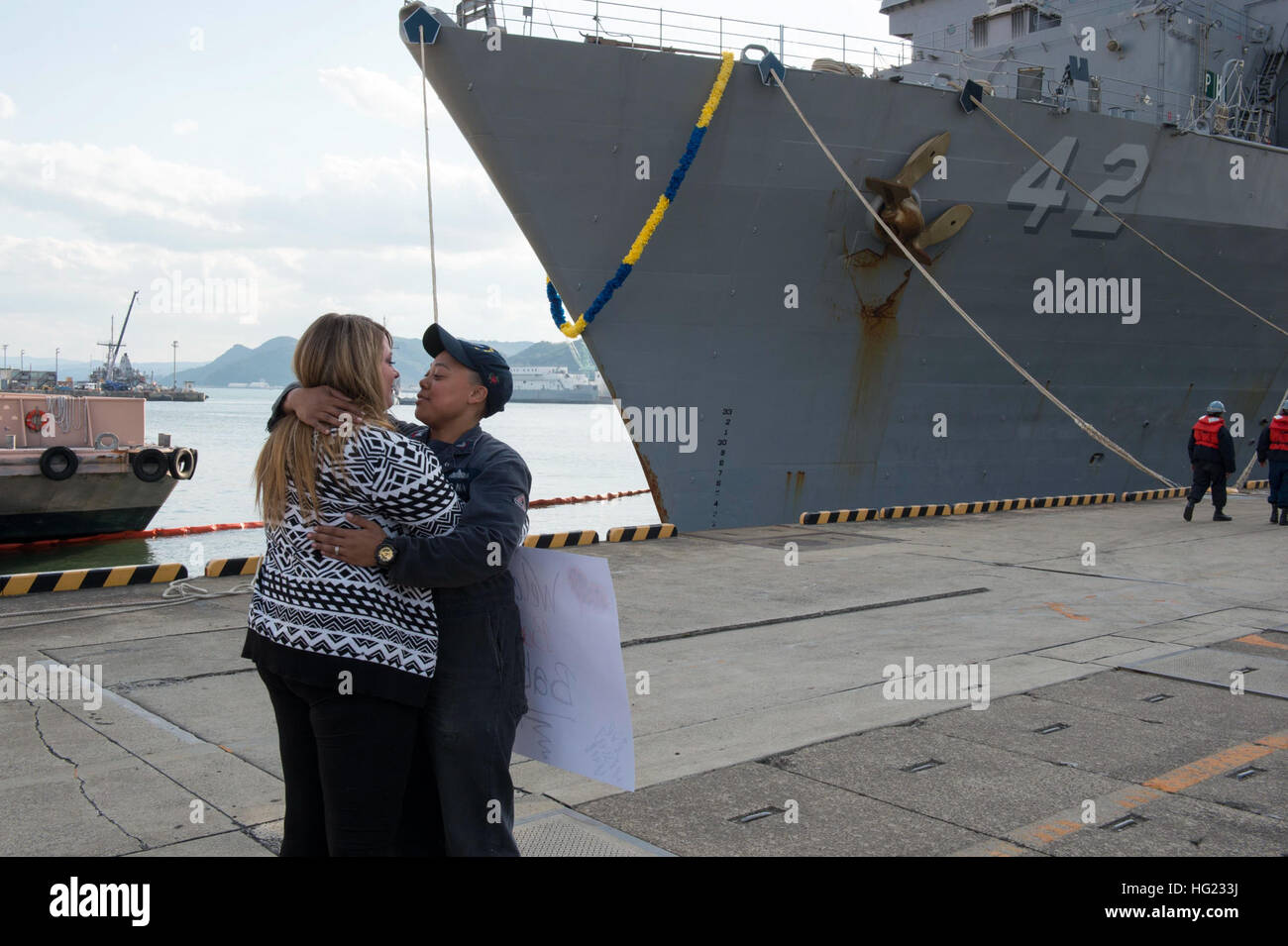 Engineman 2a classe Nikita Murphy, dal Gwinnett County, Ga., bacia la sua ragazza sul molo come il dock anfibio sbarco nave USS Germantown (LSD 42) restituisce al comandante le attività della flotta Sasebo (CFAS) dopo aver completato la sua pattuglia di caduta. Germantown è distribuito negli Stati Uniti 7 flotta area di responsabilità. (U.S. Foto di Marina di Massa lo specialista di comunicazione 2a classe Amanda R. Gray/RILASCIATO) USS Germantown restituisce al comandante le attività della flotta Sasebo 141114-N-UD469-423 Foto Stock