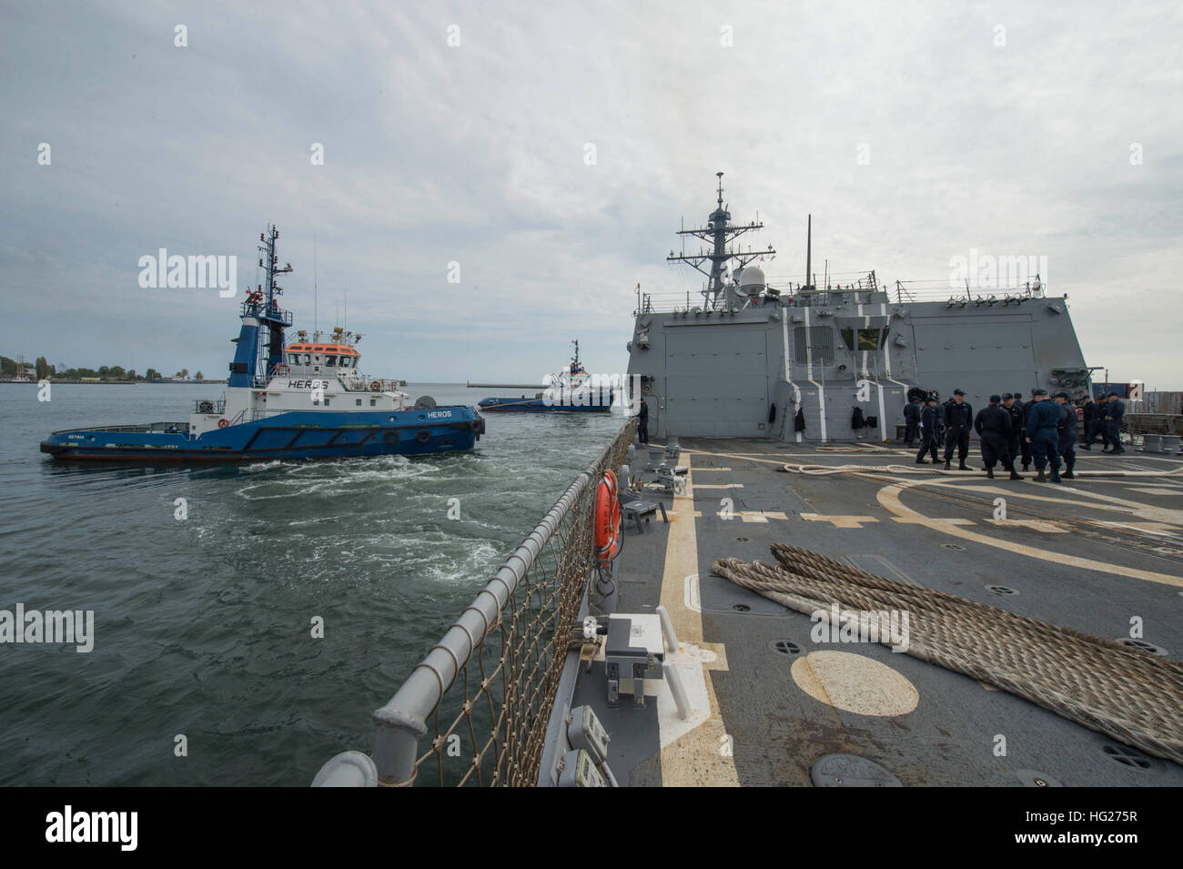 150509-N-ZE250-024 Gdynia, Polonia (9 maggio 2015) rimorchiatori manovra USS Jason Dunham (DDG 109) fuori del porto di Gdynia, Polonia, 9 maggio 2015. Jason Dunham, un Arleigh Burke-class guidato-missile distruttore, homeported in Norfolk, sta conducendo operazioni navali negli Stati Uniti Sesta flotta area di operazioni a sostegno degli Stati Uniti per gli interessi di sicurezza nazionali in Europa. (U.S. Foto di Marina di Massa lo specialista di comunicazione di terza classe Weston Jones/RILASCIATO) USS Jason Dunham 150509-N-ZE250-024 Foto Stock