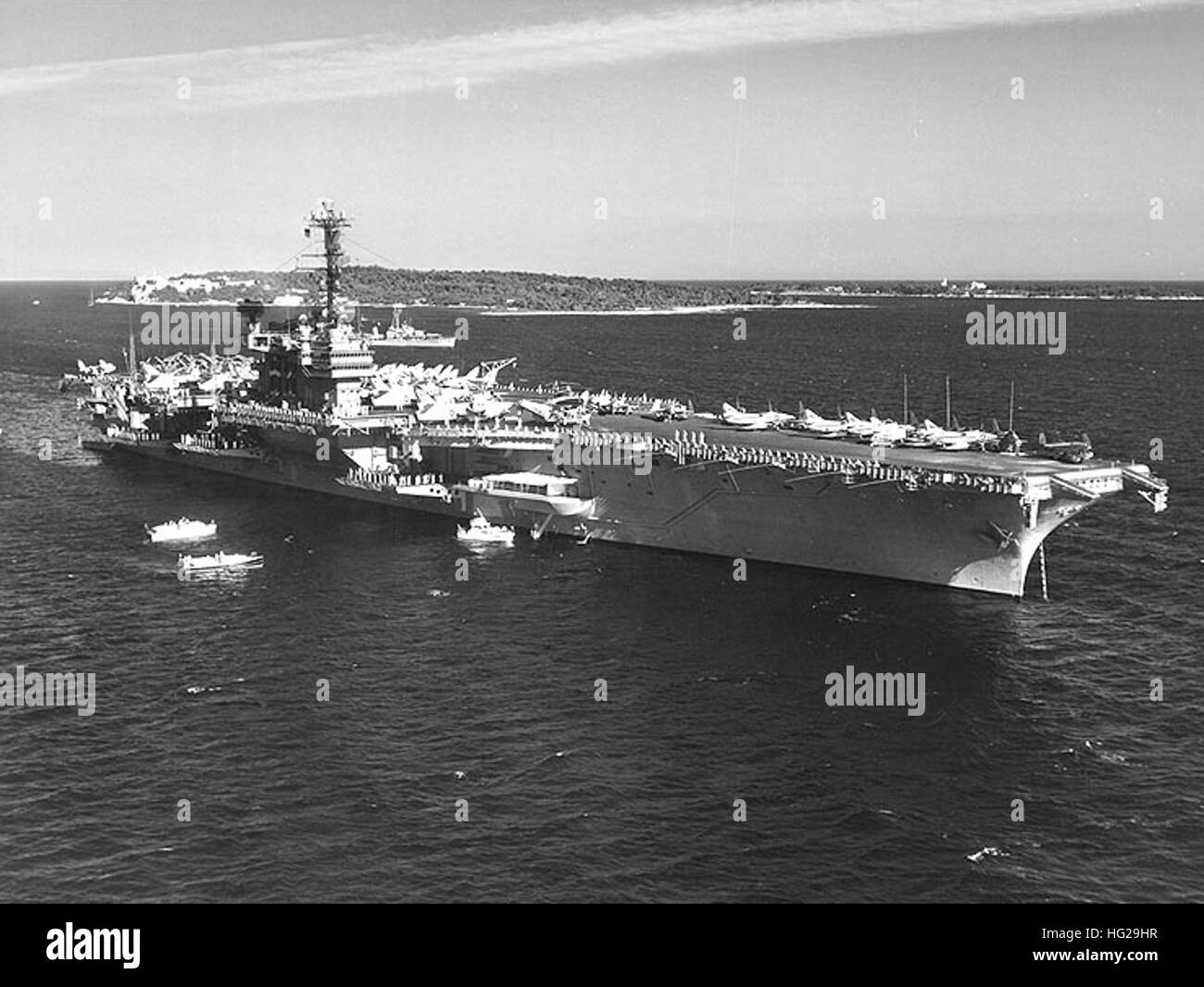 Il suo equipaggio della USS Indipendenza (CVA-62) uomo la ferrovia come la nave viene visitata dal principe Rainer e la Principessa Grace di Monaco, mentre sono ancorate al largo di Cannes, Francia, 5 luglio 1962. USS Compton (DD-705) è in background. Ufficiale DEGLI STATI UNITI Fotografia della marina. USS Indipendenza (CVA-62) off Cannes nel luglio 1962 Foto Stock