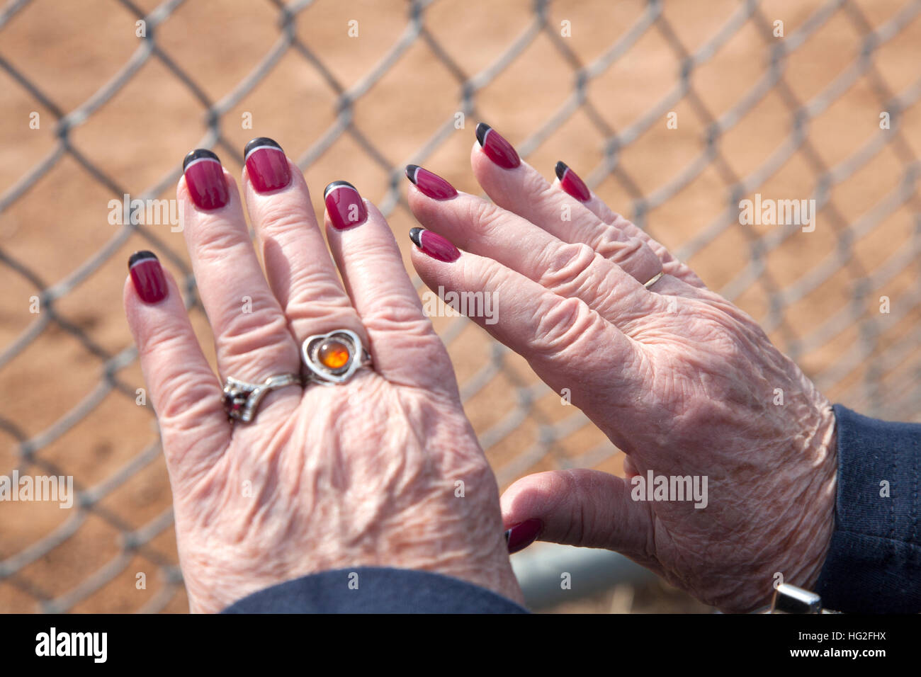 Senior donna orgogliosamente in mostra il suo più recente chiodi rosso con punte nere. St Paul Minnesota MN USA Foto Stock