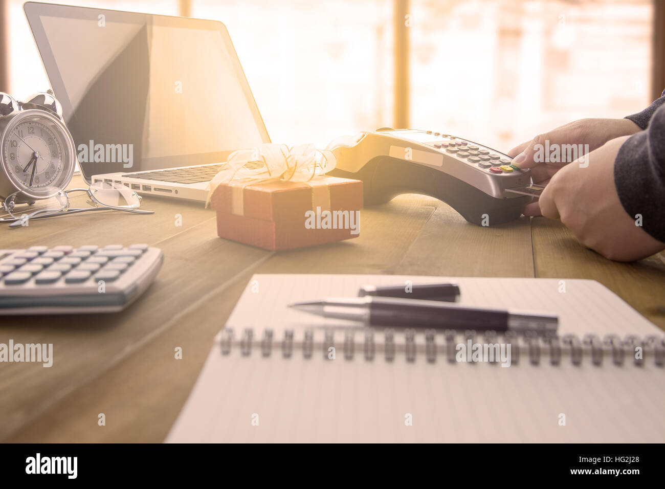 Cassiere fatto a mano di un pagamento con carta di credito e EDC macchina o terminale carte di credito con la calcolatrice e bicchieri. Caldo effetto tonificante. Foto Stock