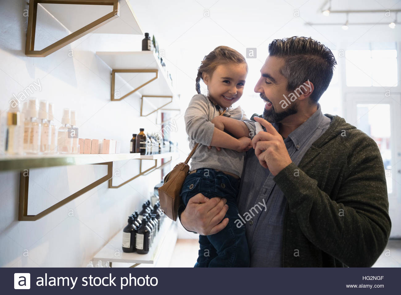 Padre e figlia di spruzzatura shopping home profumo in negozio Foto Stock