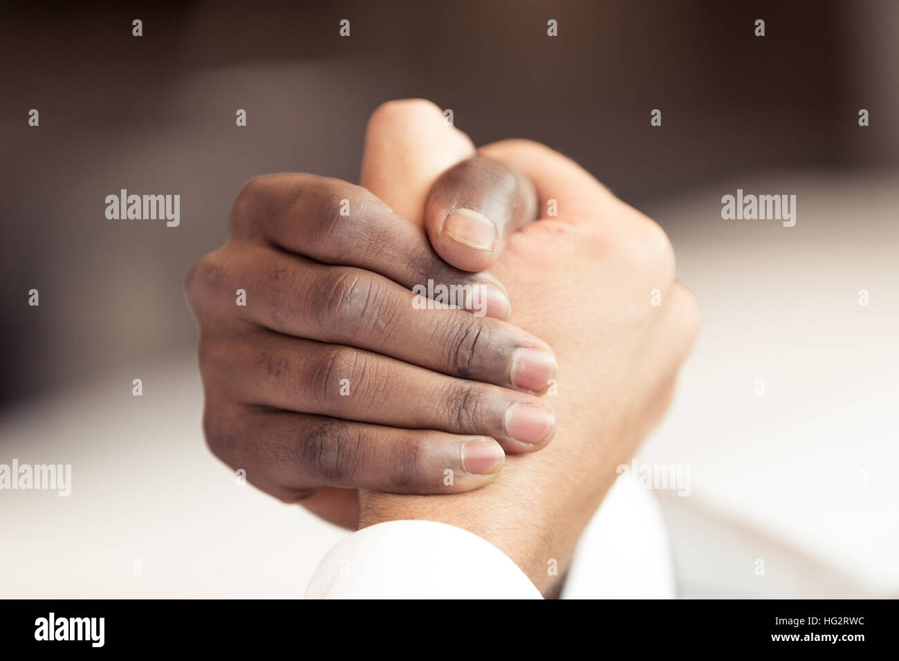 Stretta di mano tra africani e di un uomo caucasico Foto Stock