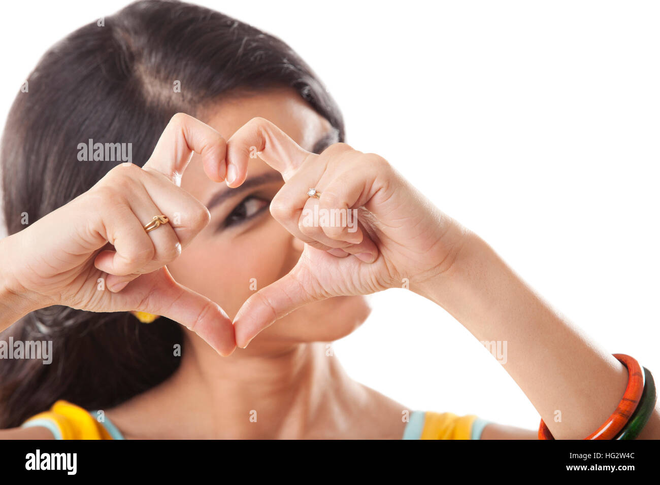 Carino giovane femmina facendo un segno di cuore isolato su bianco Foto Stock
