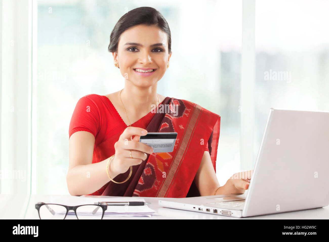 Donna indiana lo shopping online con carta di credito Foto Stock