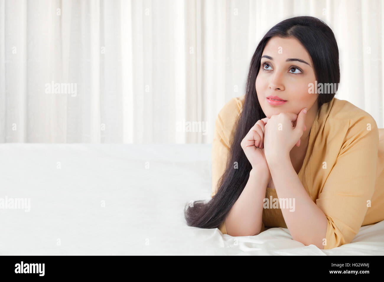 La donna posa sul letto Foto Stock