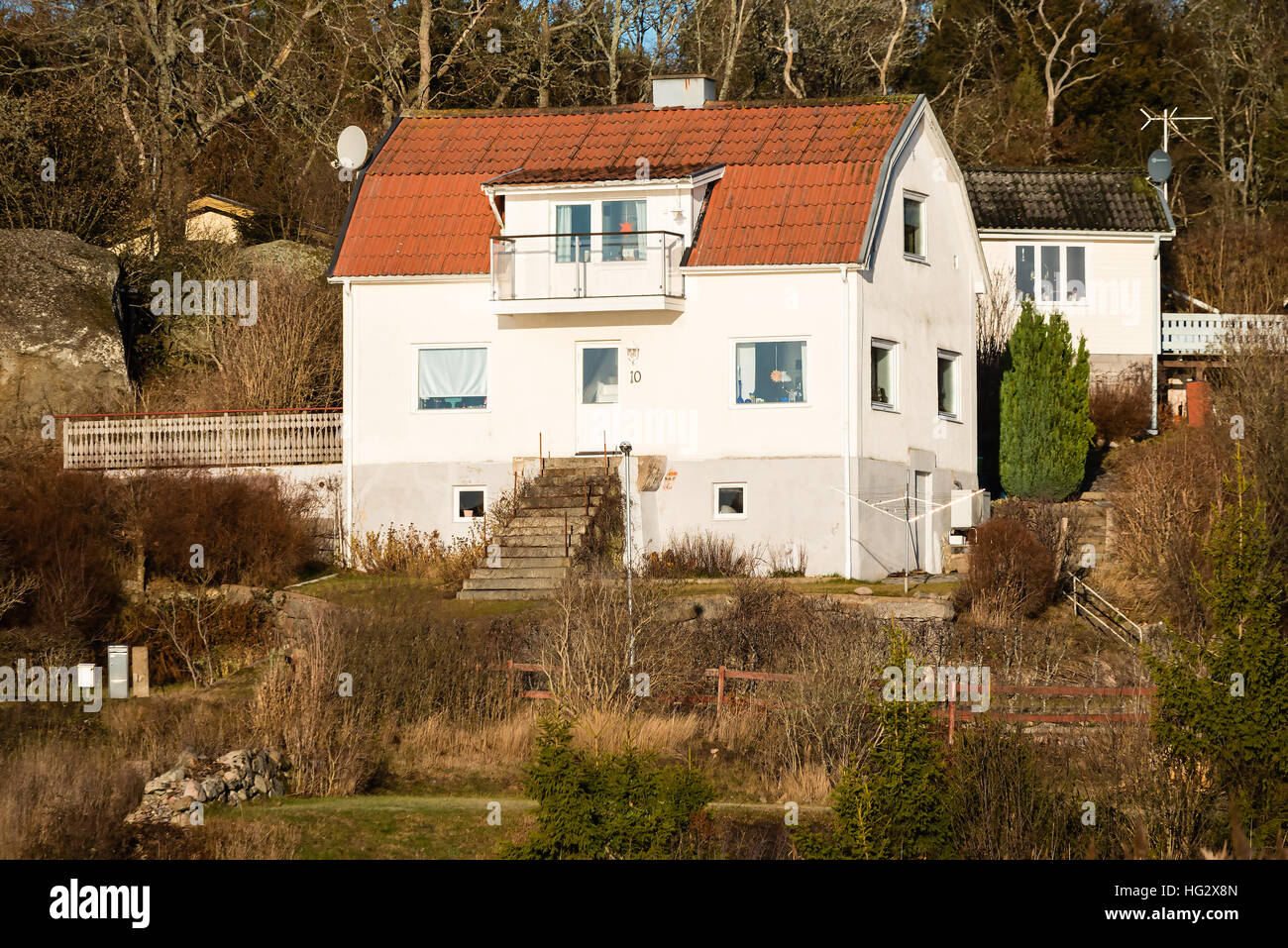 Ronneby, Svezia - 2 Gennaio 2017: documentario di stile di vita rurale. Tipica collina svedese home con bosco in background. Un po' giardino selvaggio. Foto Stock