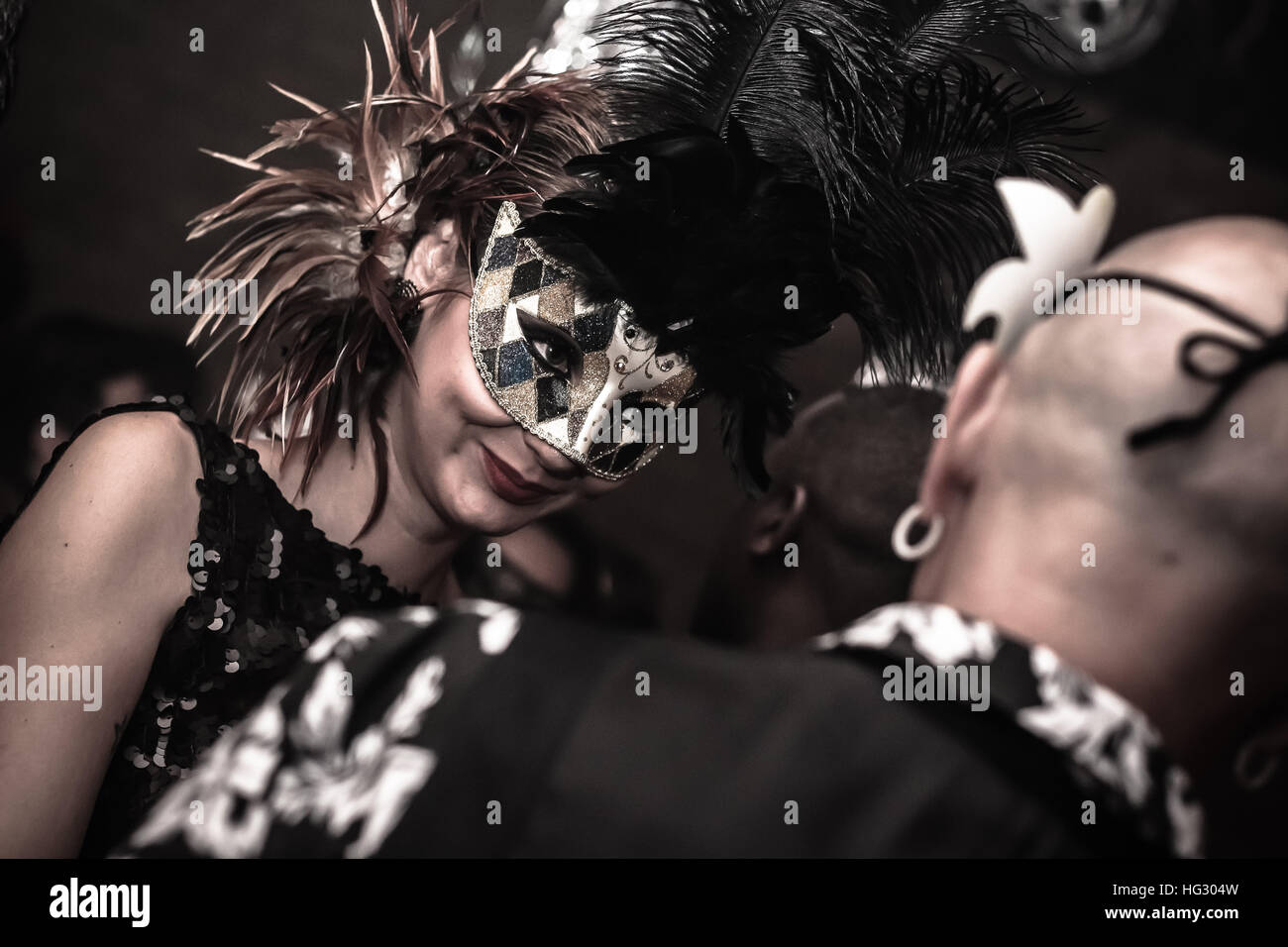 Una misteriosa e bella donna in maschera nera guardando qualcun altro Foto Stock