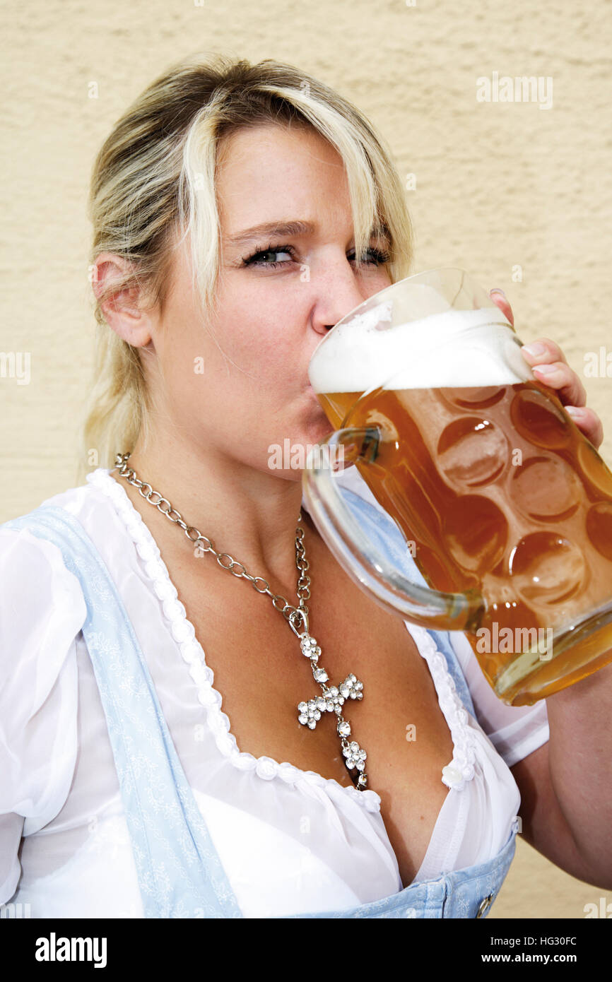 Cameriera bavarese indossando dirndl bevendo una birra stein (boccale di birra) Foto Stock