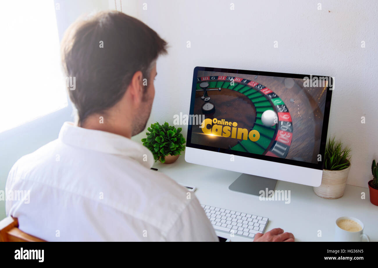 L'uomo gioca online casino. Tutti i grafici dello schermo sono costituiti. Foto Stock