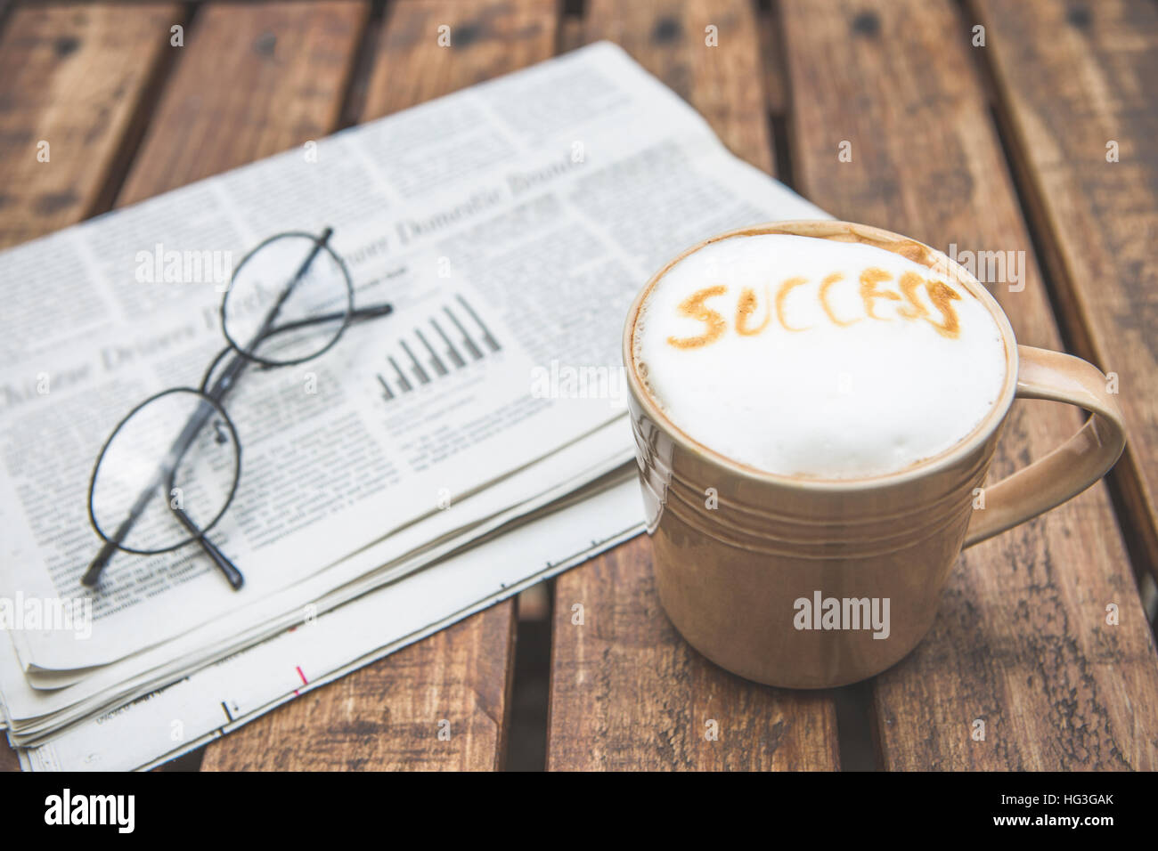Tazza di caffè con una formulazione ' successo' e bicchieri sul giornale aziendale Foto Stock