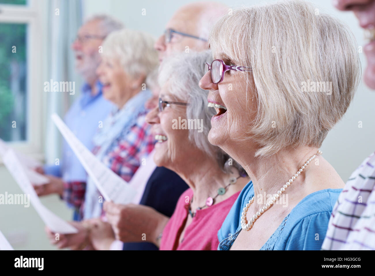 Gruppo di anziani a cantare in coro insieme Foto Stock