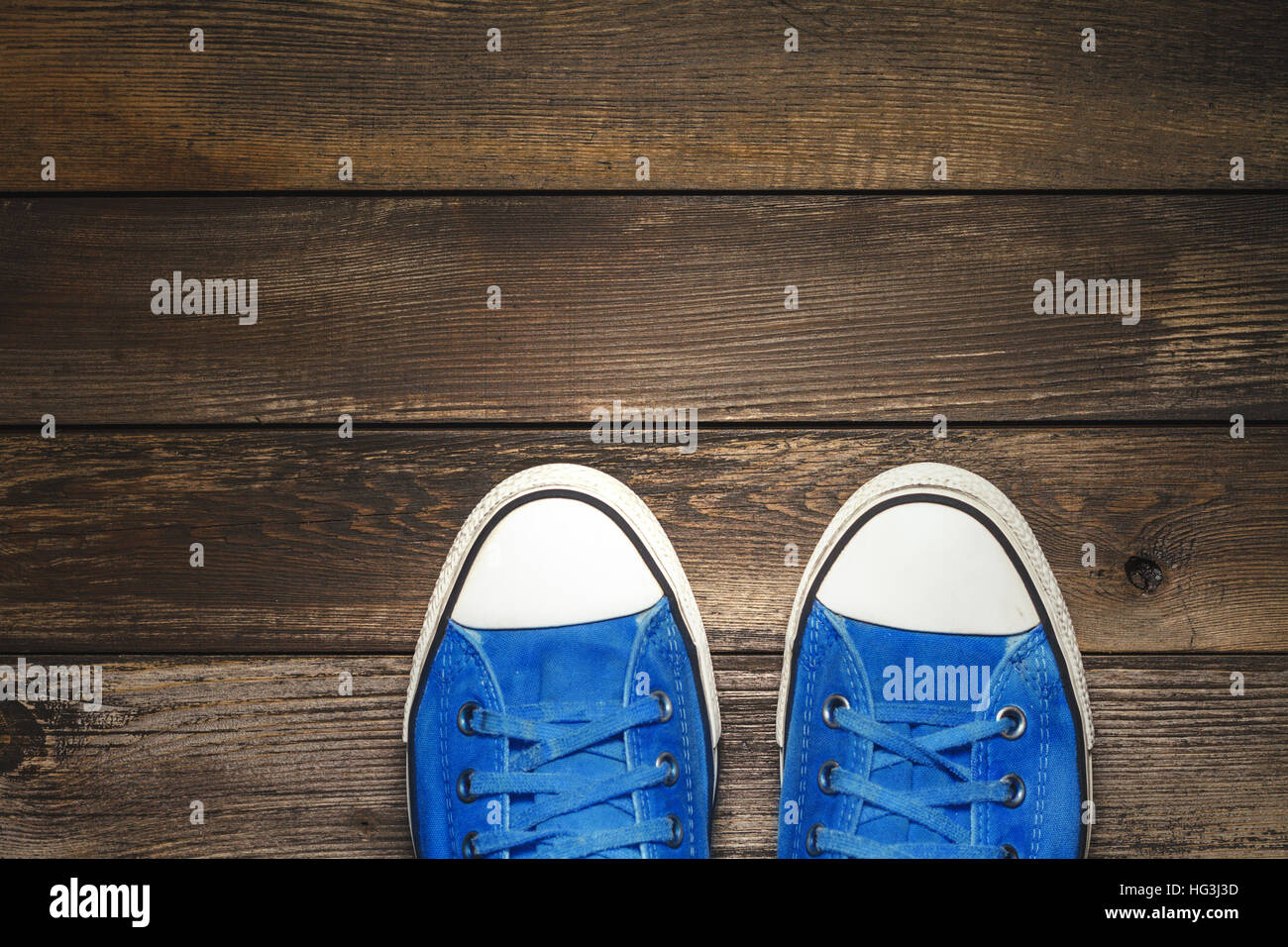 Sneakers blu sul pavimento in legno Foto Stock