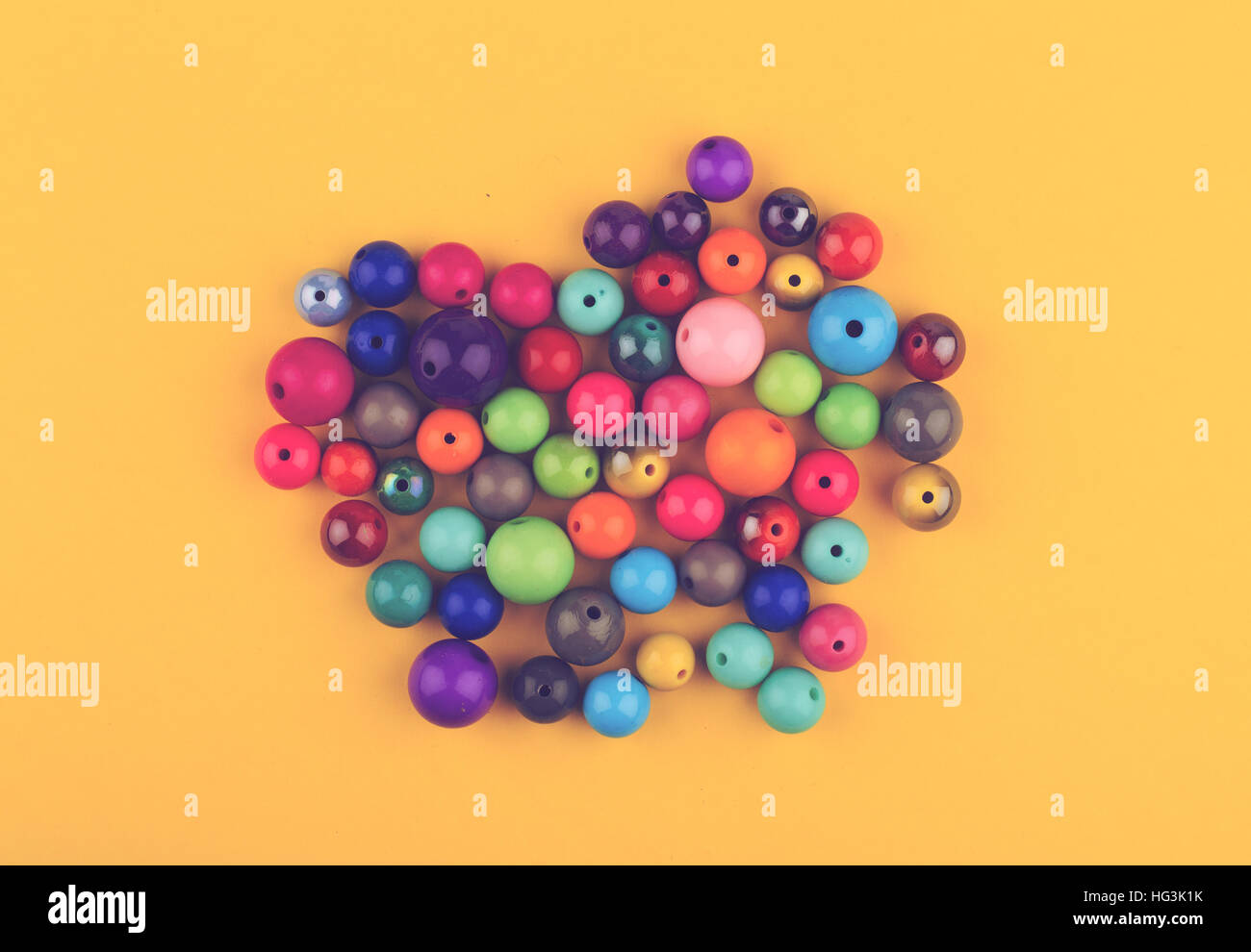 Vista superiore molti vetri colorati perle perle per gioielli su sfondo giallo Foto Stock