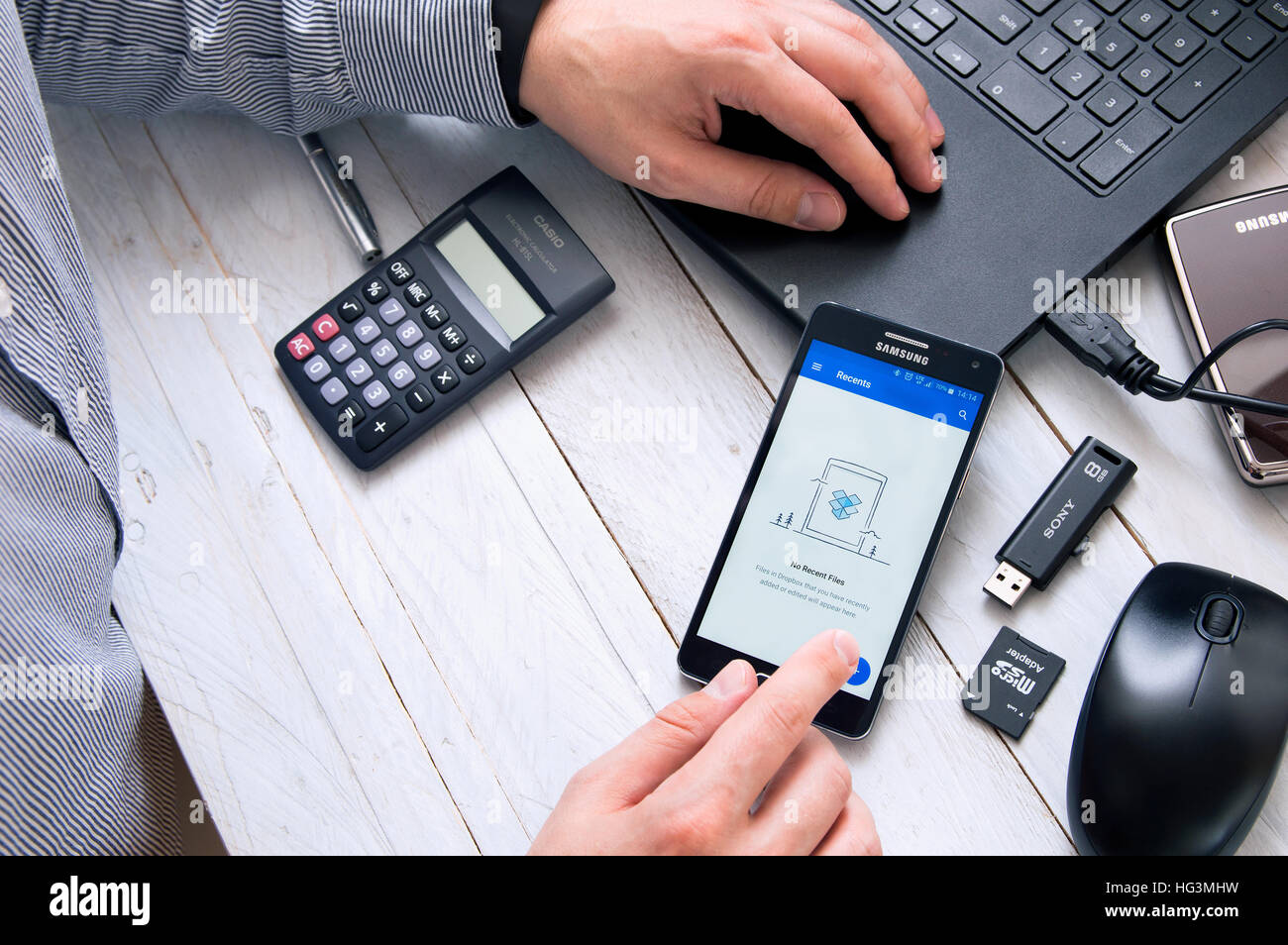 WROCLAW, Polonia- Ottobre 05th, 2016: uomo lancia Dropbox applicazione su Samsung A5. Dropbox è un file del servizio di hosting gestito dalla società americana D Foto Stock