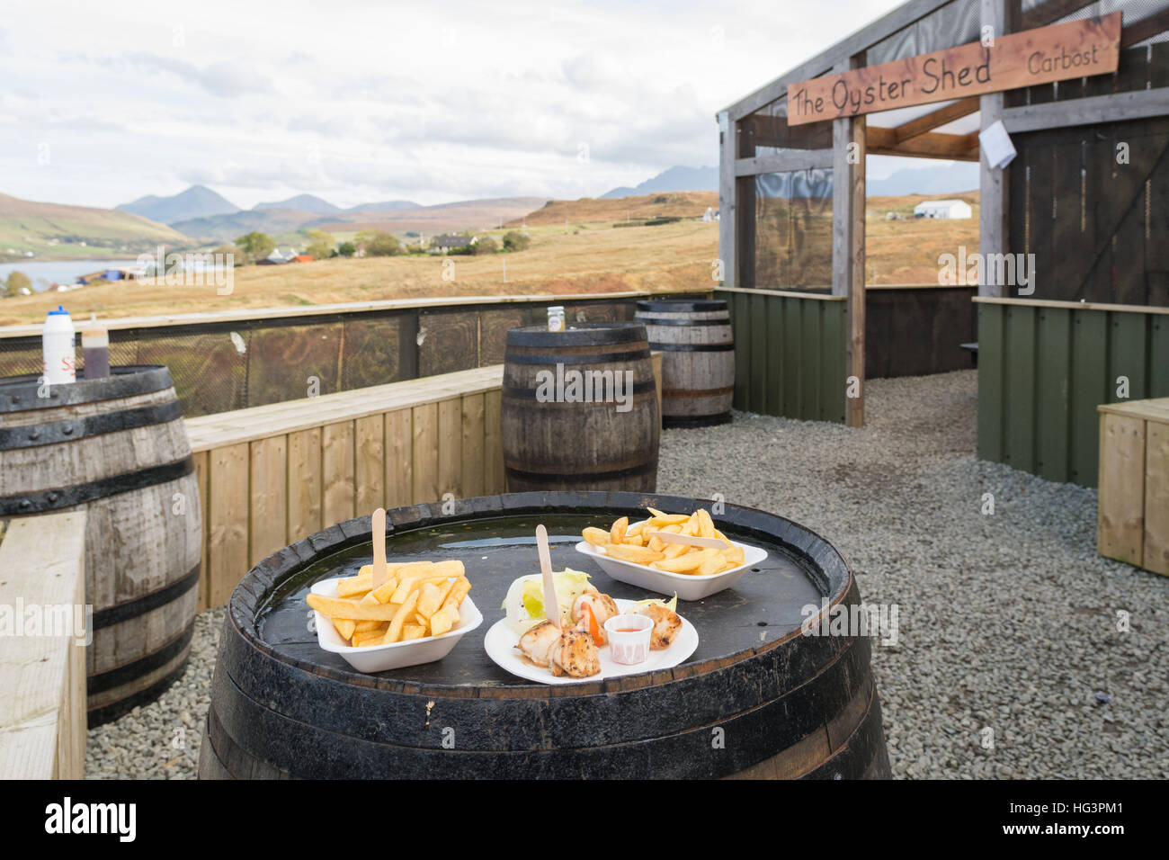 Il capannone di ostriche, Isola di Skye in Scozia - capesante fresche e i chip sulla canna di whisky tabelle Foto Stock
