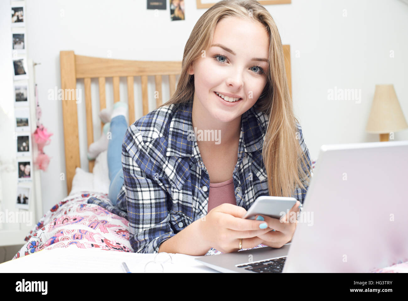 Ragazza adolescente utilizzando il telefono cellulare mentre lo studio Foto Stock