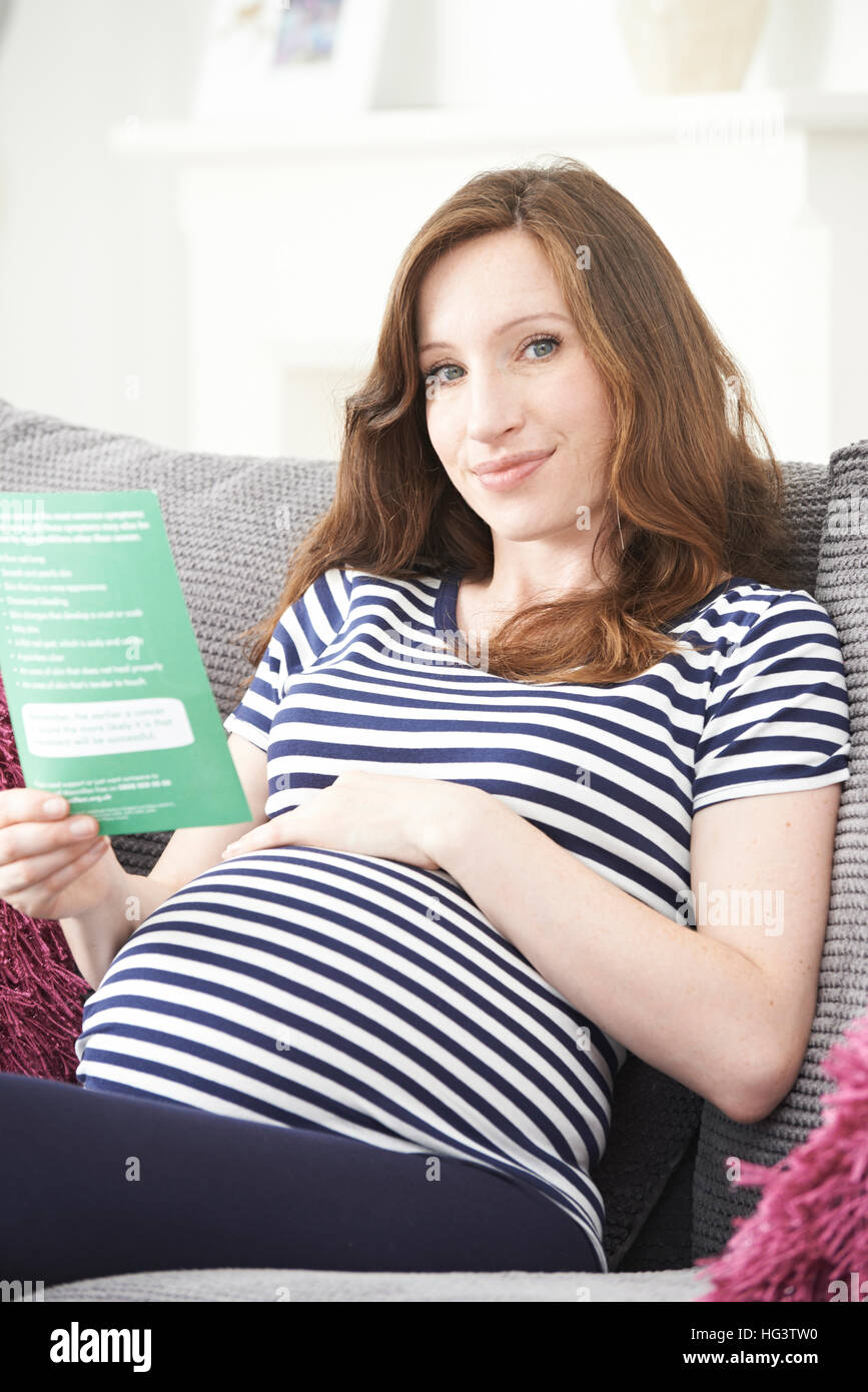 Donna incinta foglietto di lettura con una consulenza medica Foto Stock