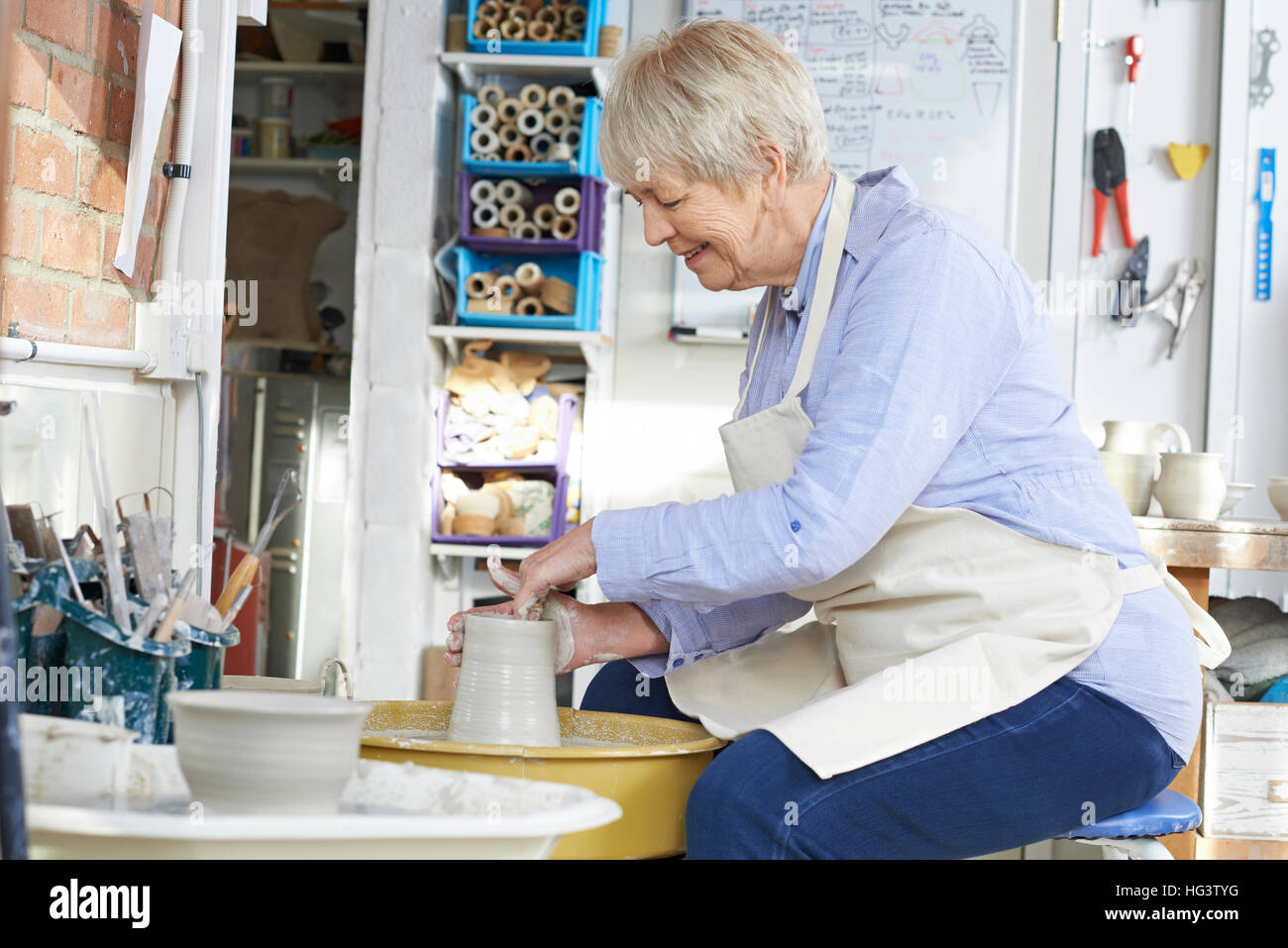 Senior donna che lavorano a ruota di ceramiche in Studio Foto Stock