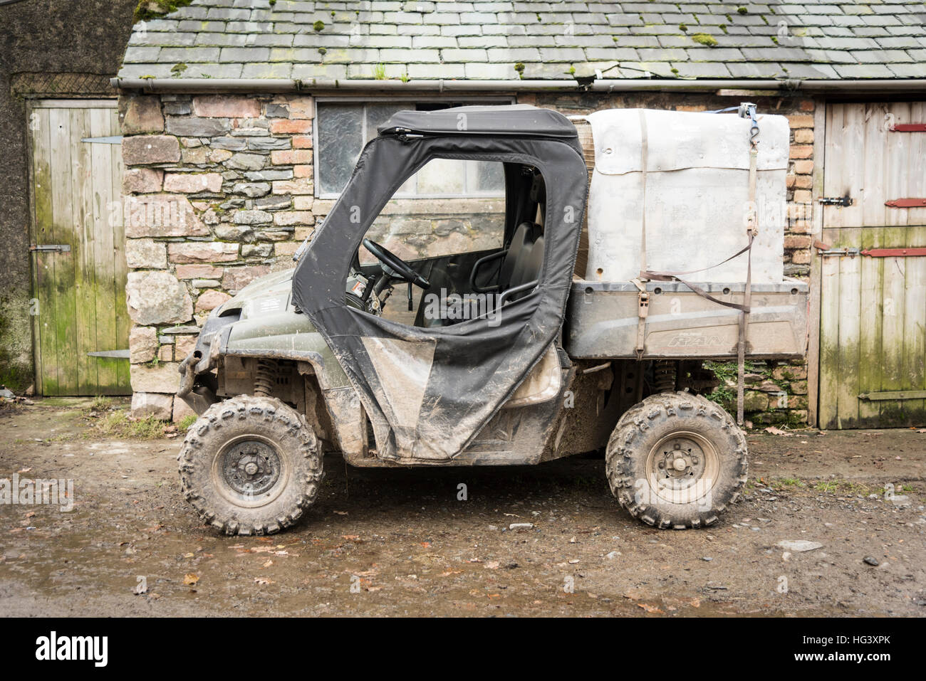 Un fangoso polaris ranger tutti i terreni off road veicolo agricolo o quad in una fattoria in Cumbria Regno Unito Foto Stock