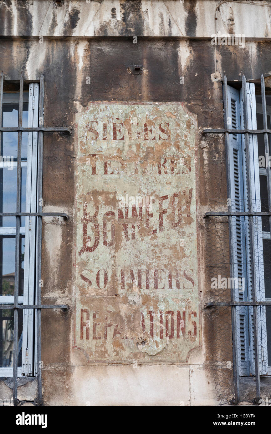 Il vecchio muro sbiadito signage pubblicità un letto tradizionale attività di riparazioni in Aix-en-Provence, Francia. Foto Stock