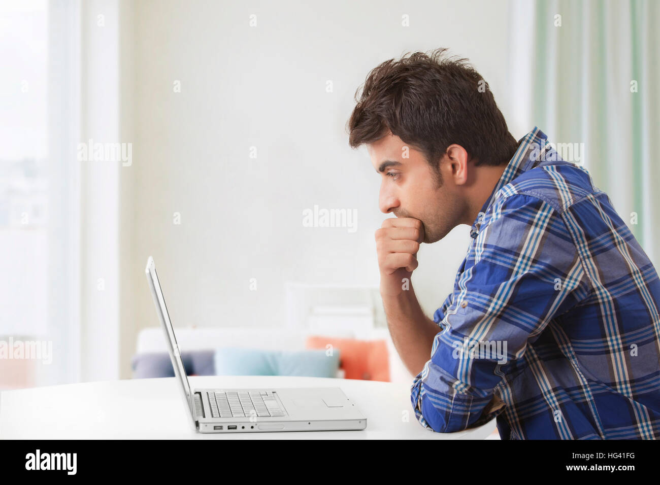 Giovane uomo utilizzando il computer portatile Foto Stock