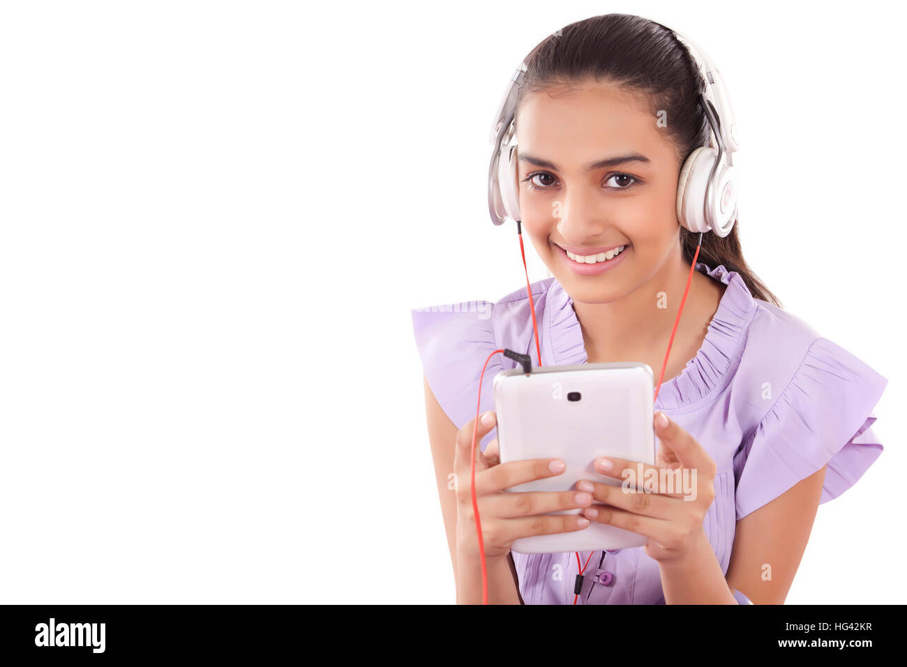 Le ragazze adolescenti godendo della sua musica ascolto di un set di auricolari attaccati al suo tablet Foto Stock